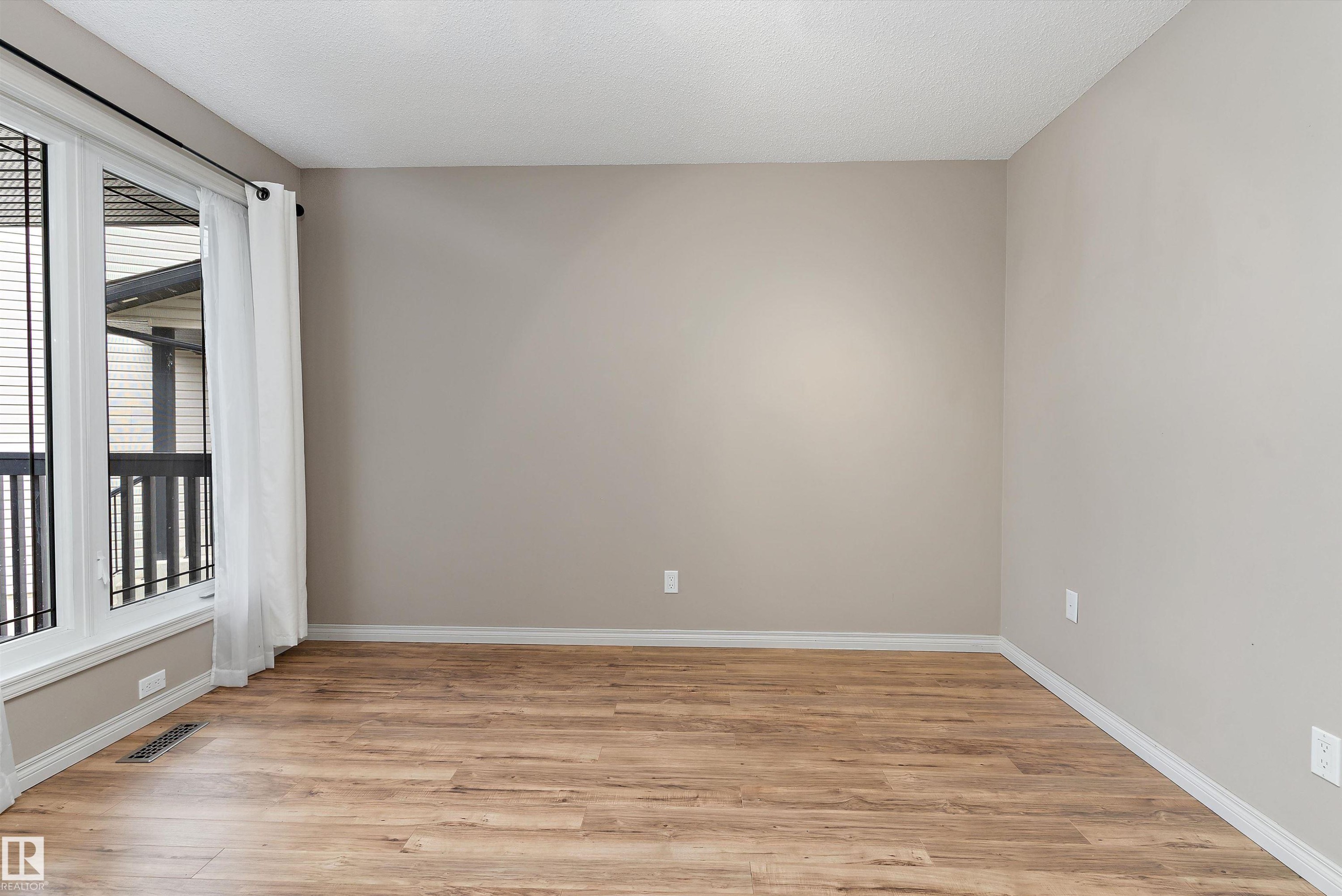Wood-finish flooring with neutral wall paint and white trim - 20845 92A Avenue Nw, Edmonton, AB - Indoor Photo Showing Other Room