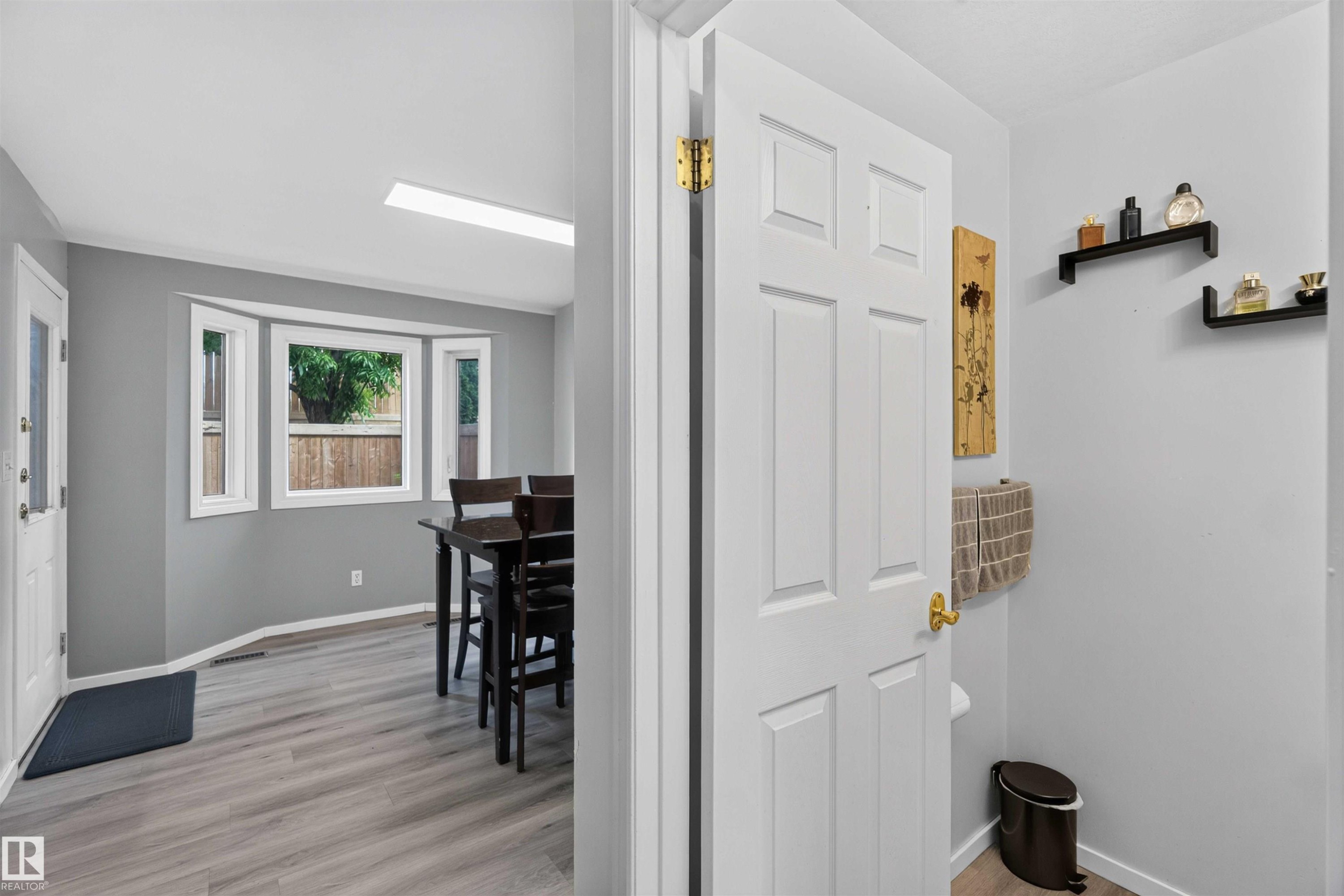 Bay window with white trim, wood-finish flooring, white paneled interior door, and recessed lighting - #28 3645 145 Av Nw, Edmonton, AB - Indoor Photo Showing Other Room