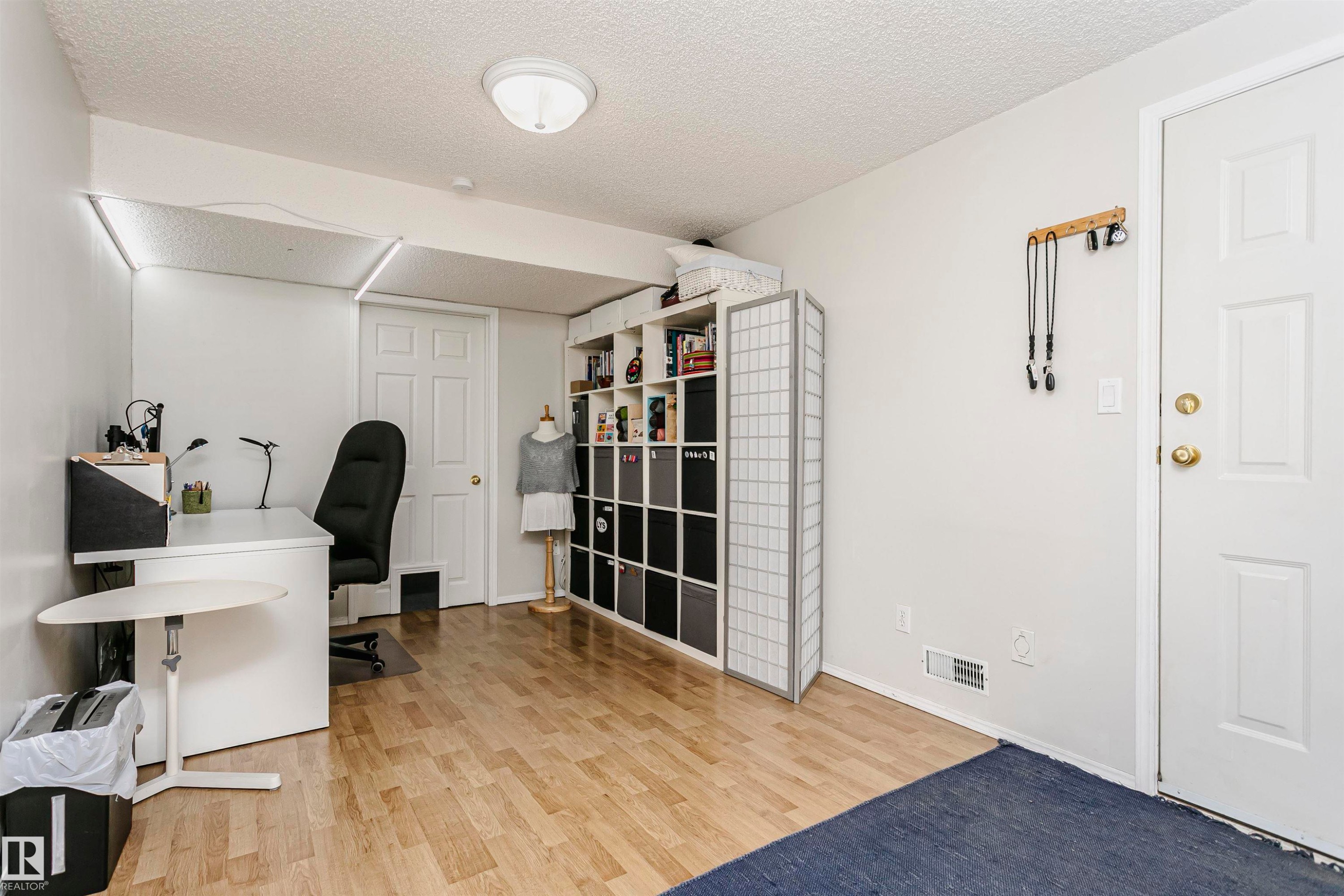 Wood-finish flooring with white walls and a paneled door - #42 9630 176 St Nw, Edmonton, AB - Indoor