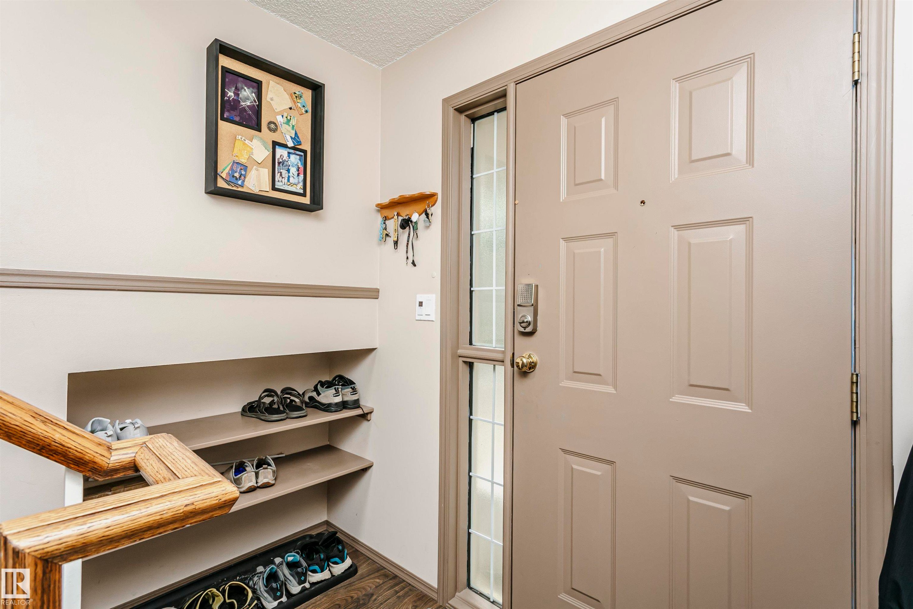 Entry door with sidelight, paneled construction, and brass hardware - #42 9630 176 St Nw, Edmonton, AB - Indoor Photo Showing Other Room