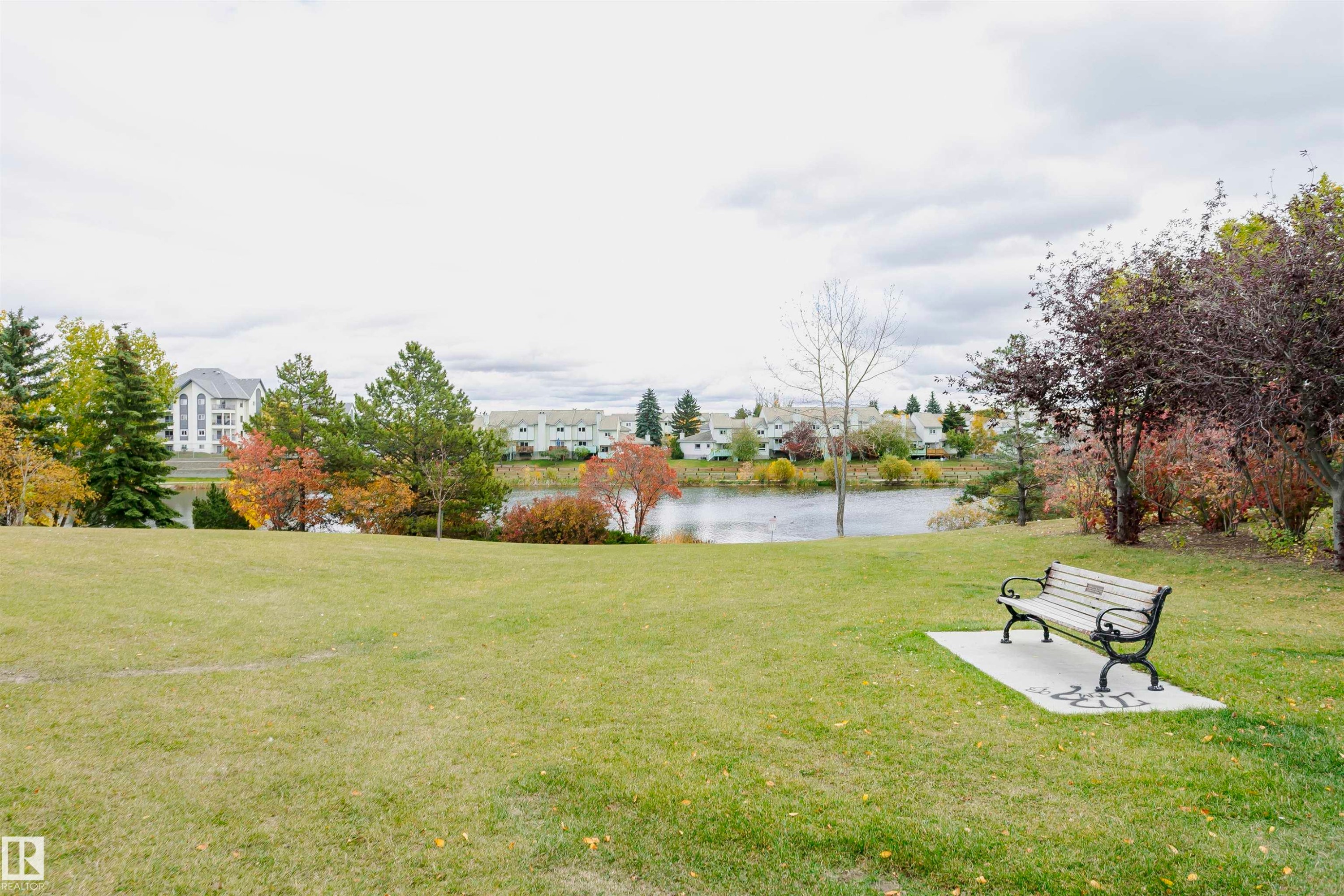 Expansive green space featuring a serene body of water and mature trees - #42 9630 176 St Nw, Edmonton, AB - Outdoor With View