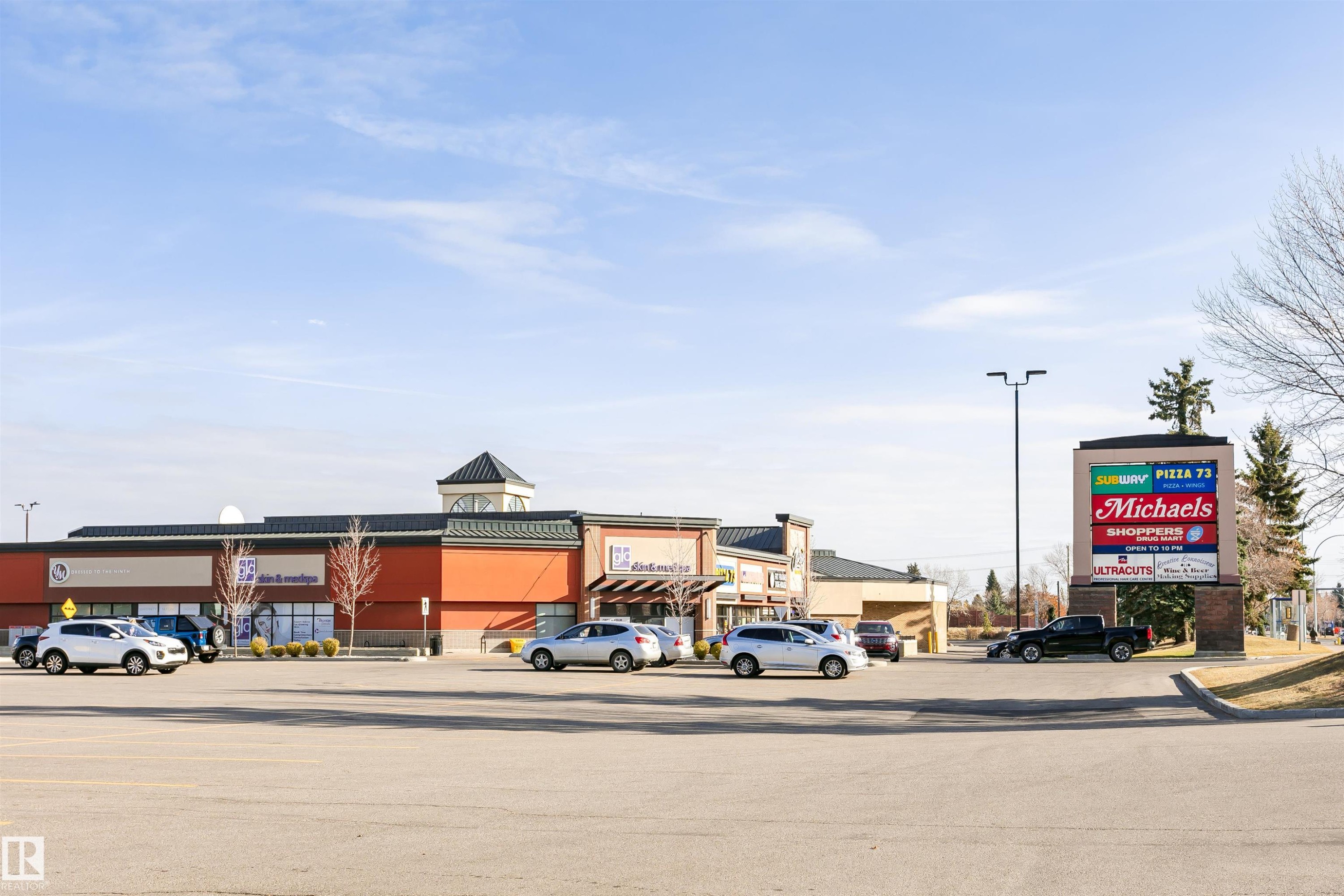 Commercial complex featuring a prominent pylon sign and ample surface parking - #42 9630 176 St Nw, Edmonton, AB - Outdoor