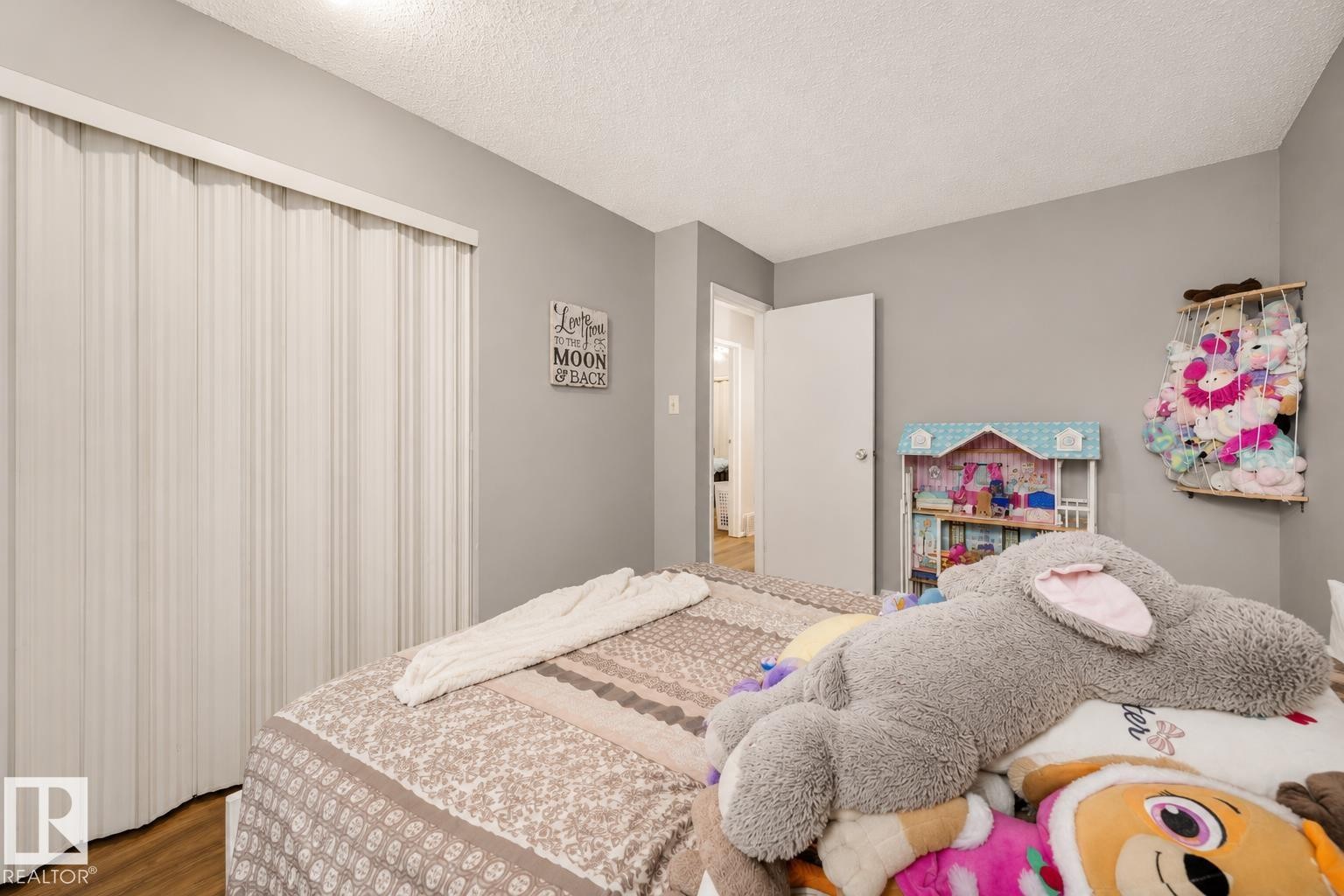 Light gray wall paint, wood-finish flooring, white ceiling, flush-mount lighting, and bi-fold closet doors - #44 1415 62 St Nw, Edmonton, AB - Indoor Photo Showing Bedroom