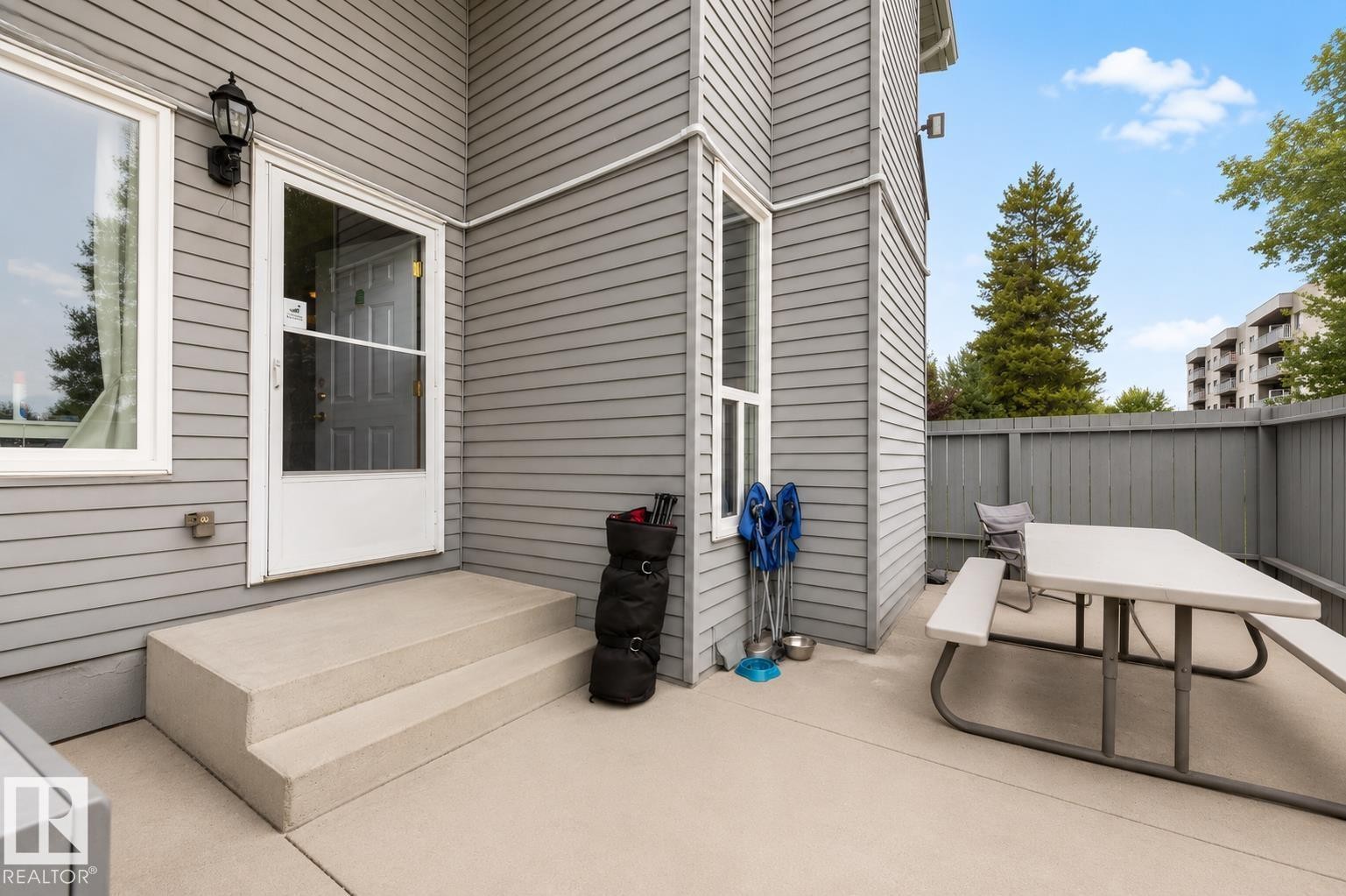 Gray horizontal siding exterior with white window trim and exterior lighting fixture - #44 1415 62 St Nw, Edmonton, AB - Outdoor With Deck Patio Veranda With Exterior