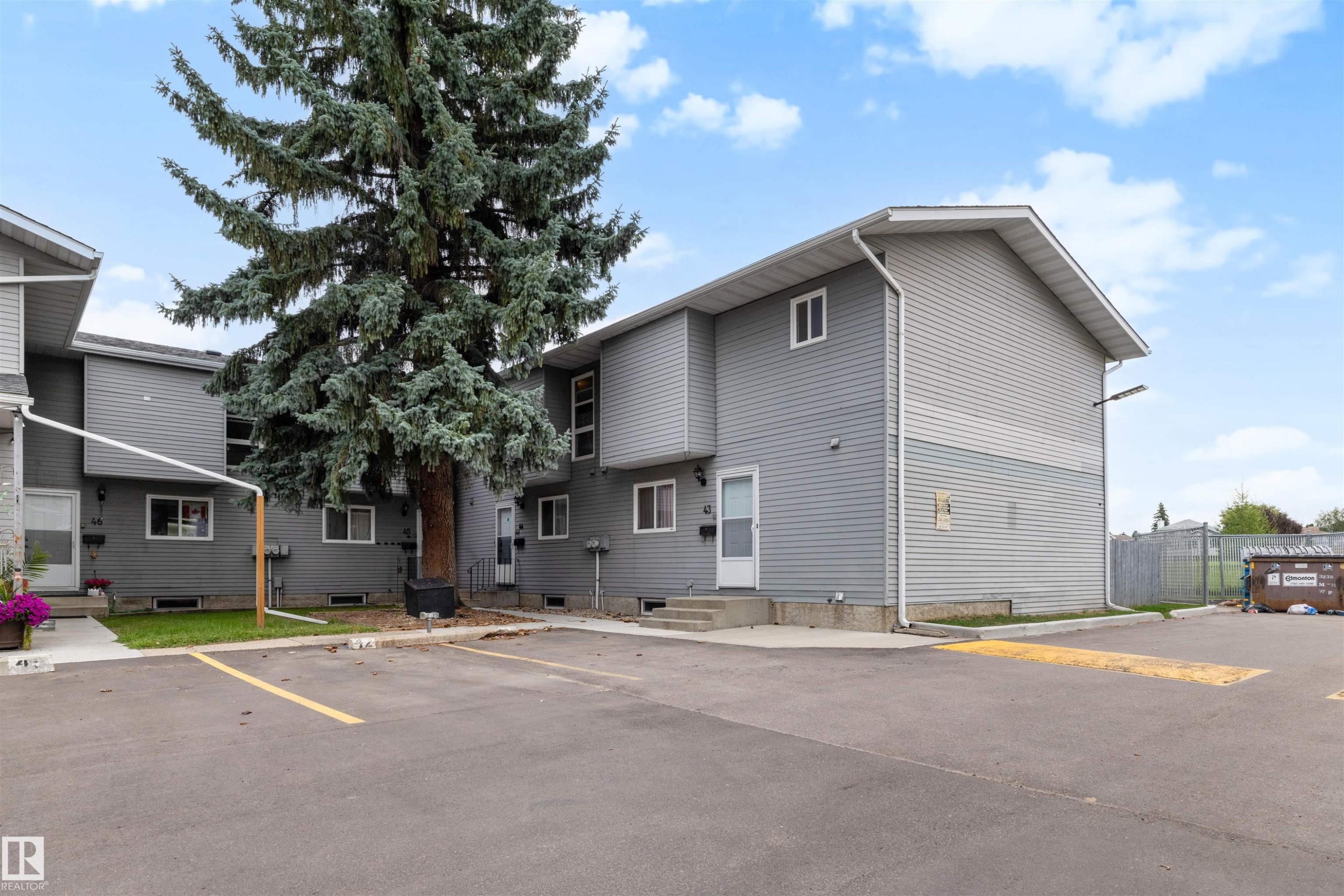 Exterior featuring horizontal siding, multiple windows, a paved parking area, and mature landscaping - #44 1415 62 St Nw, Edmonton, AB - Outdoor With Facade