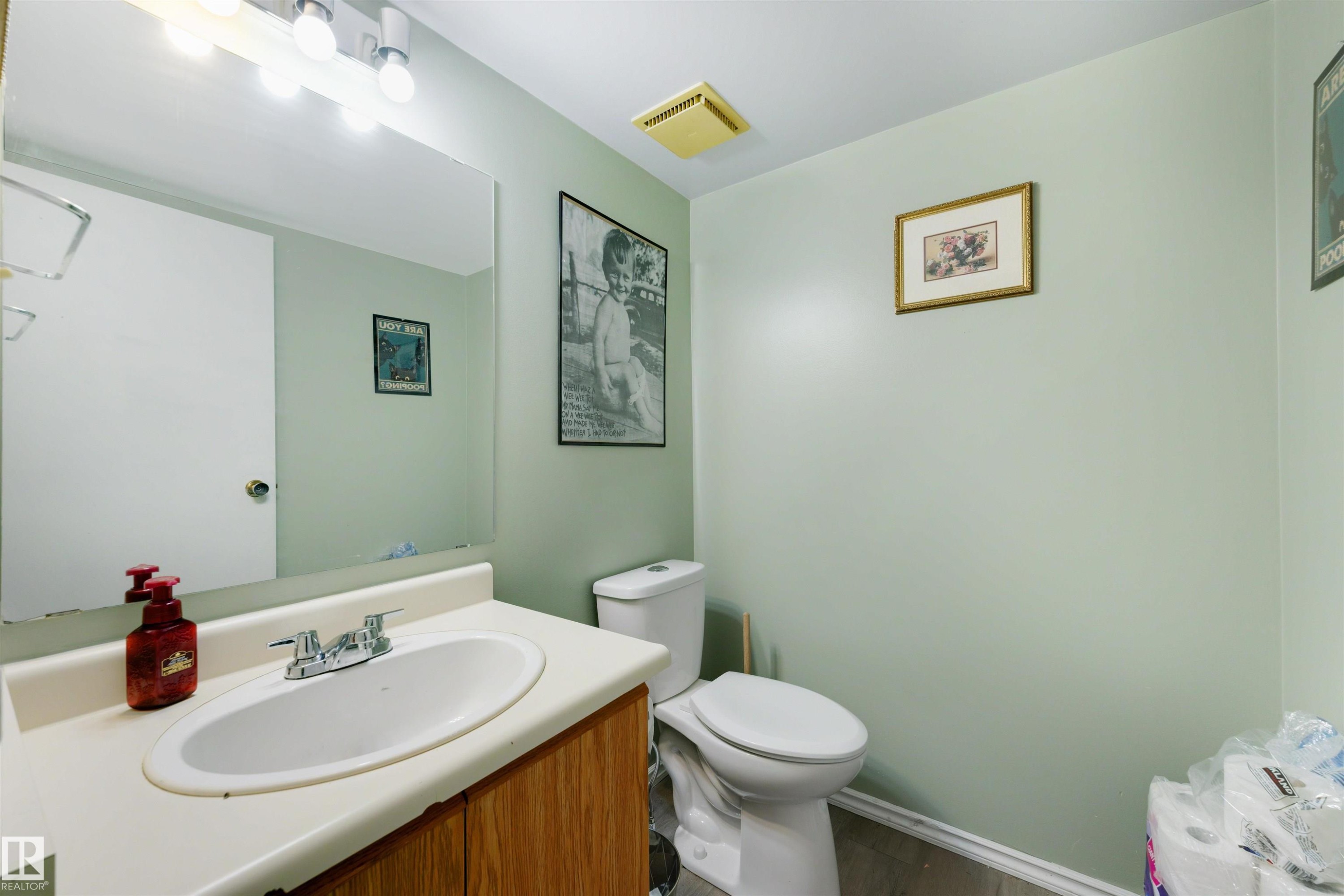 Vanity with integrated sink, chrome faucet, and wood-finish cabinetry - #44 1415 62 St Nw, Edmonton, AB - Indoor Photo Showing Bathroom