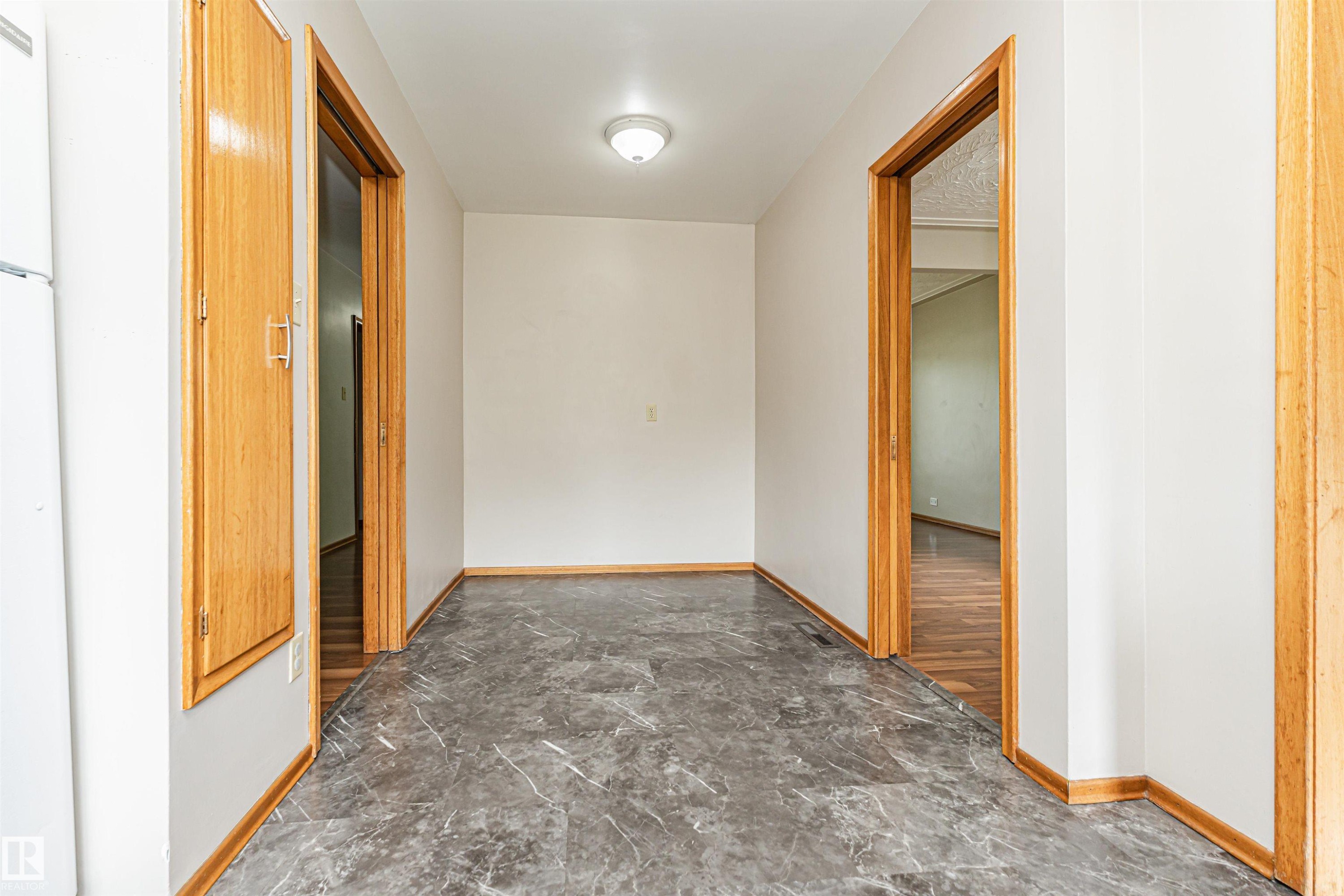 Marble-look flooring, light-toned walls, wooden door frames, and a flush mount ceiling light - 11139 62 Avenue Nw, Edmonton, AB - Indoor Photo Showing Other Room
