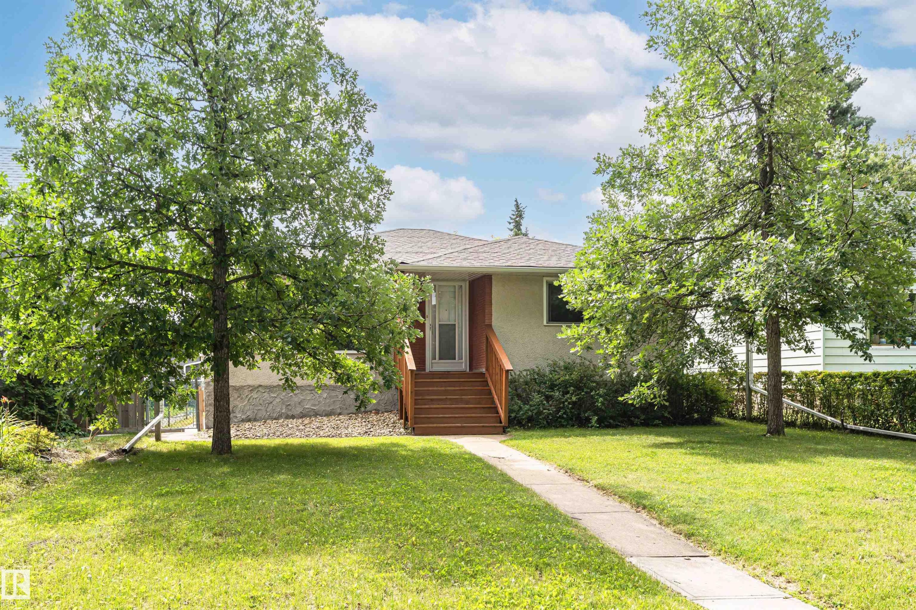 Manicured lawn, mature trees, concrete pathway, and wood-finish stairs leading to the entry - 11139 62 Avenue Nw, Edmonton, AB - Outdoor