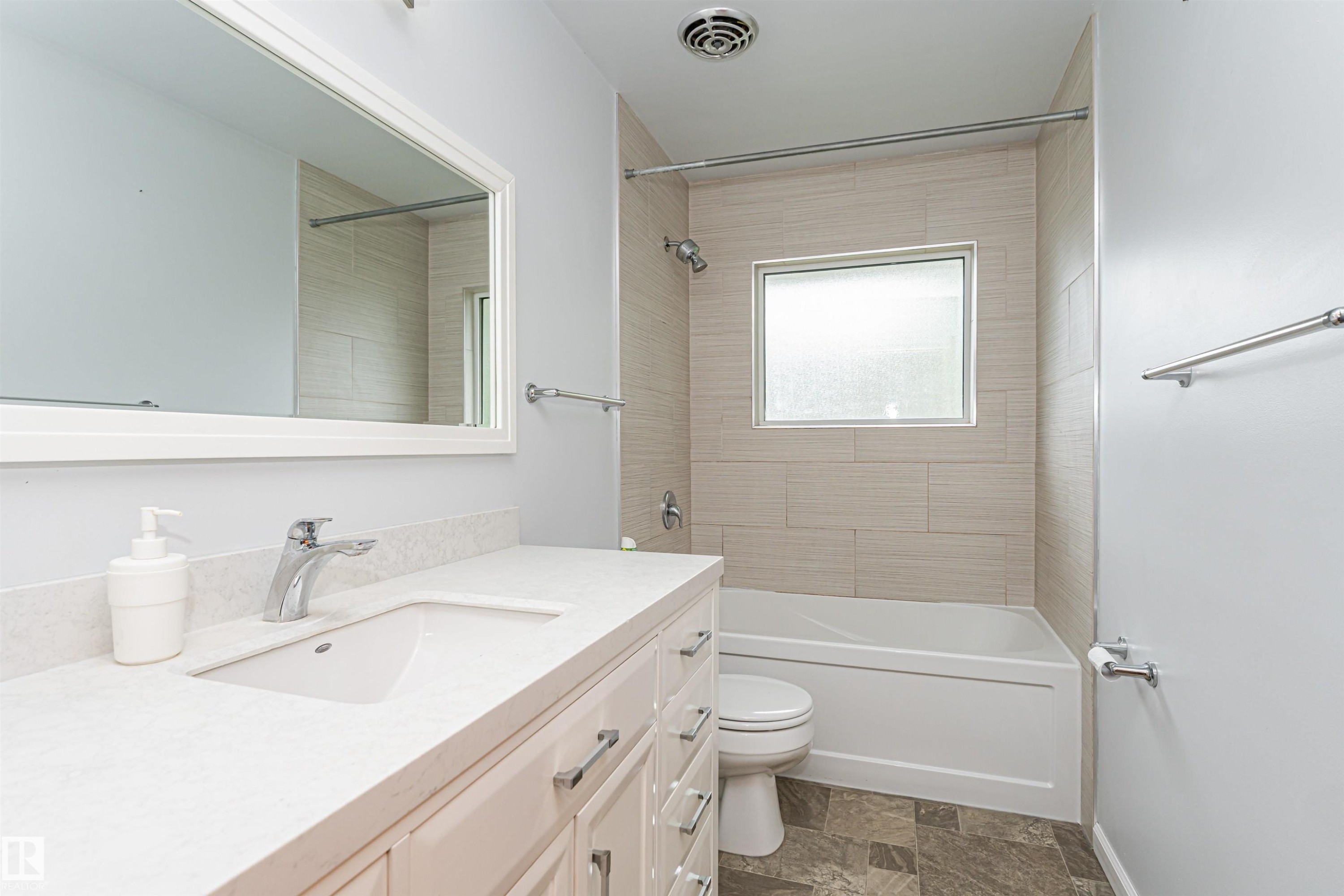 White vanity with a rectangular undermount sink, a chrome faucet, and a light-toned countertop - 11139 62 Avenue Nw, Edmonton, AB - Indoor Photo Showing Bathroom