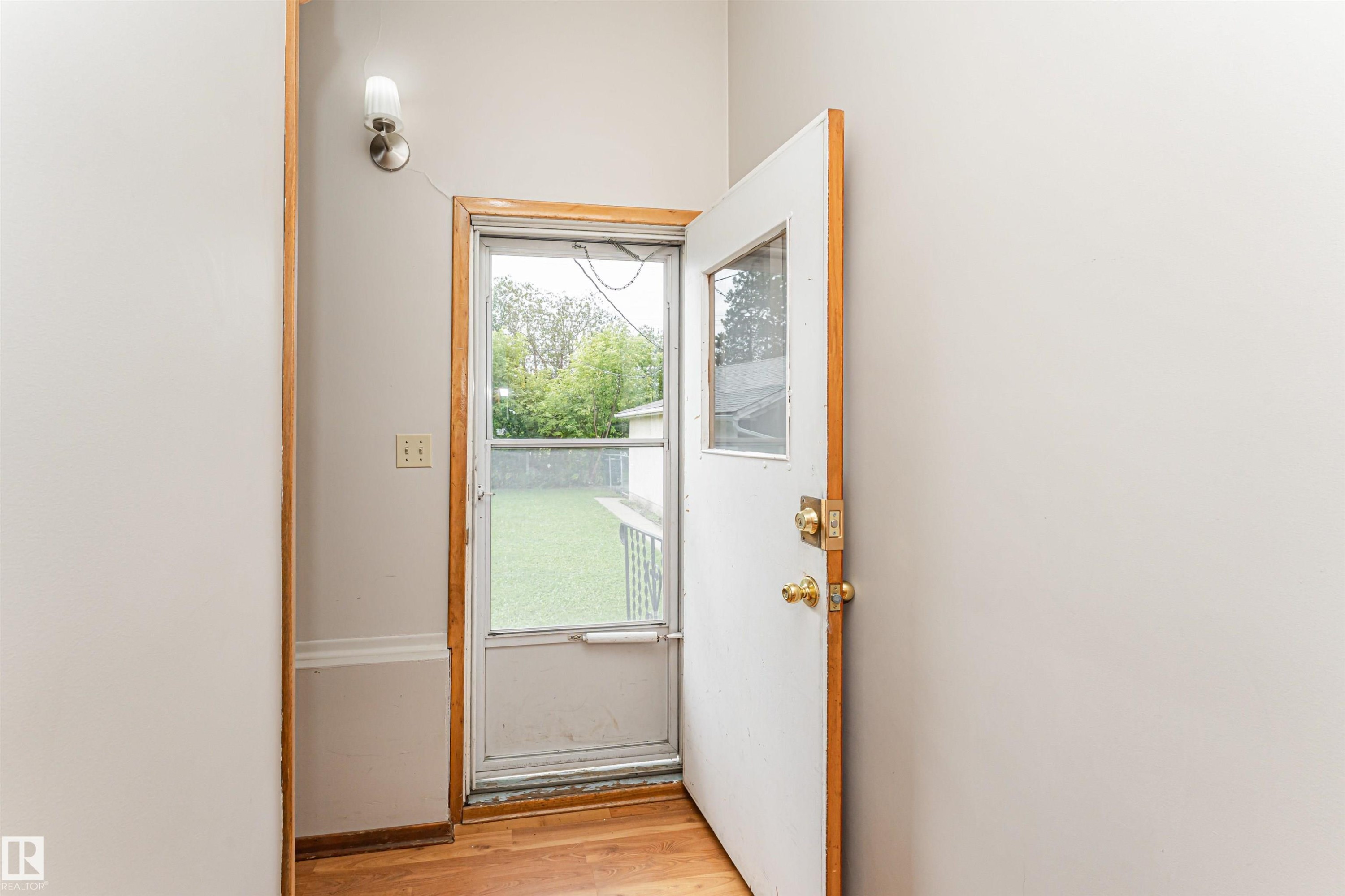 Hardwood flooring, recessed wall sconce, white interior door, and a screen door with upper glass panel - 11139 62 Avenue Nw, Edmonton, AB - Indoor Photo Showing Other Room