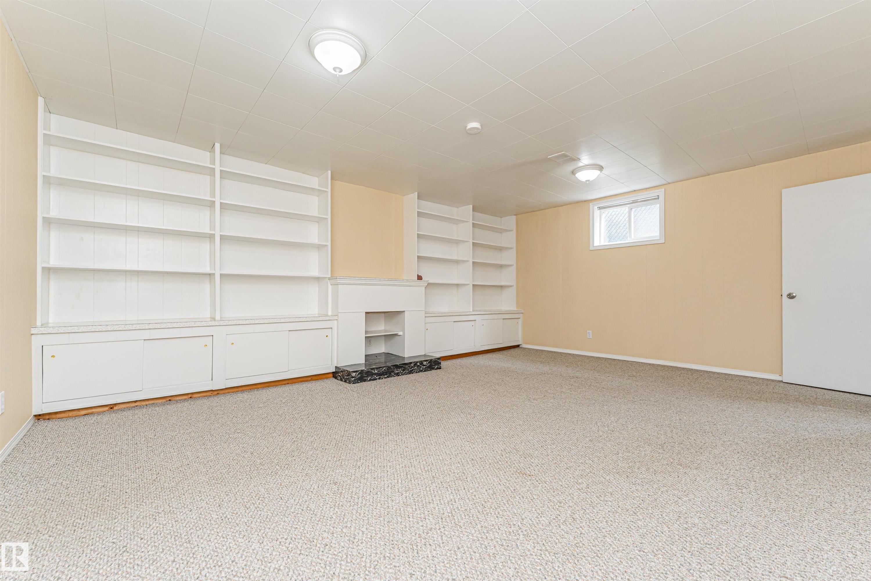 Built-in shelving and cabinetry, fireplace with a dark stone hearth, recessed window, and wall-mounted lighting fixtures - 11139 62 Avenue Nw, Edmonton, AB - Indoor