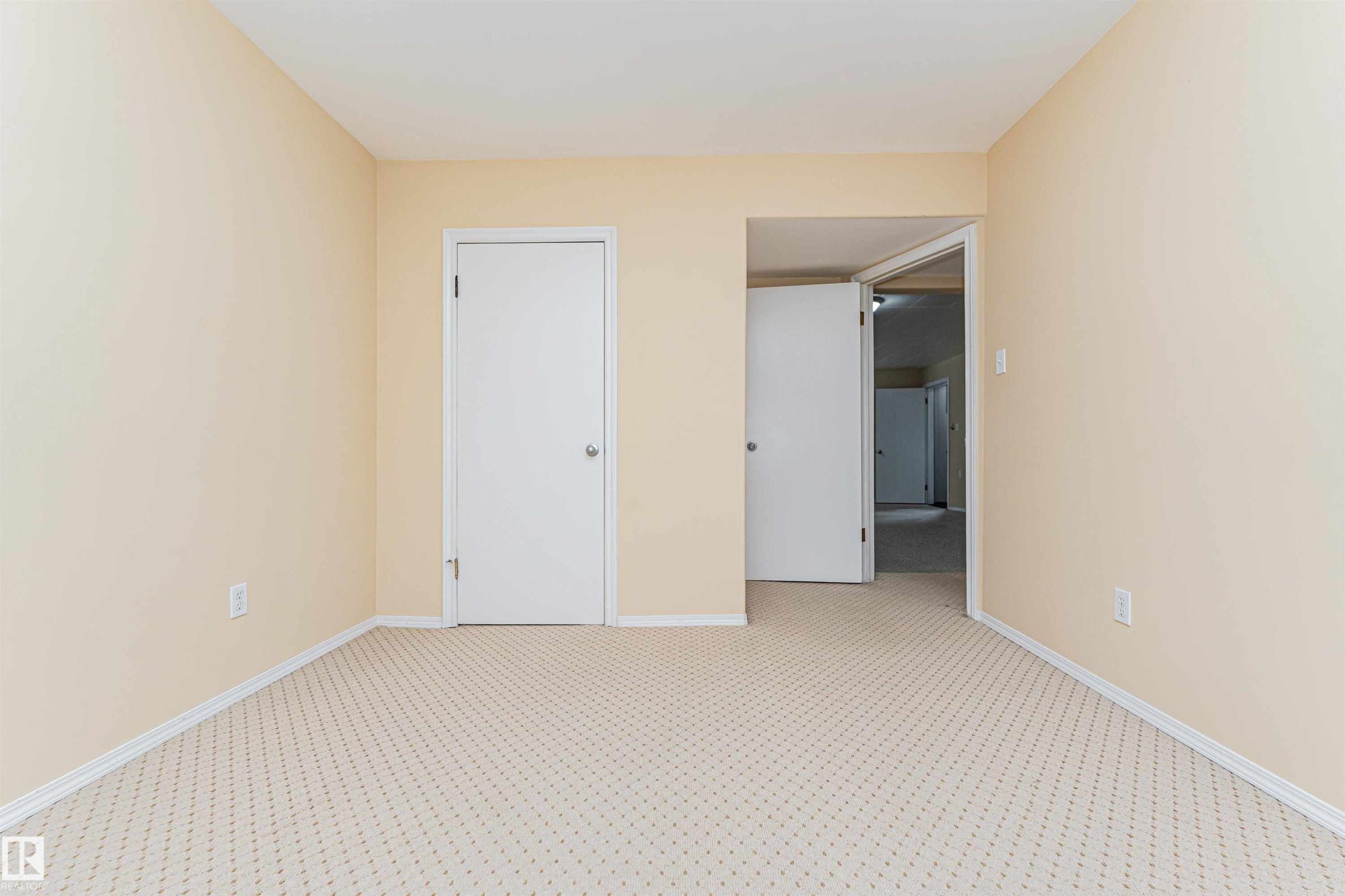 Neutral wall finishes with white trim, patterned carpet flooring, and multiple entryways - 11139 62 Avenue Nw, Edmonton, AB - Indoor Photo Showing Other Room