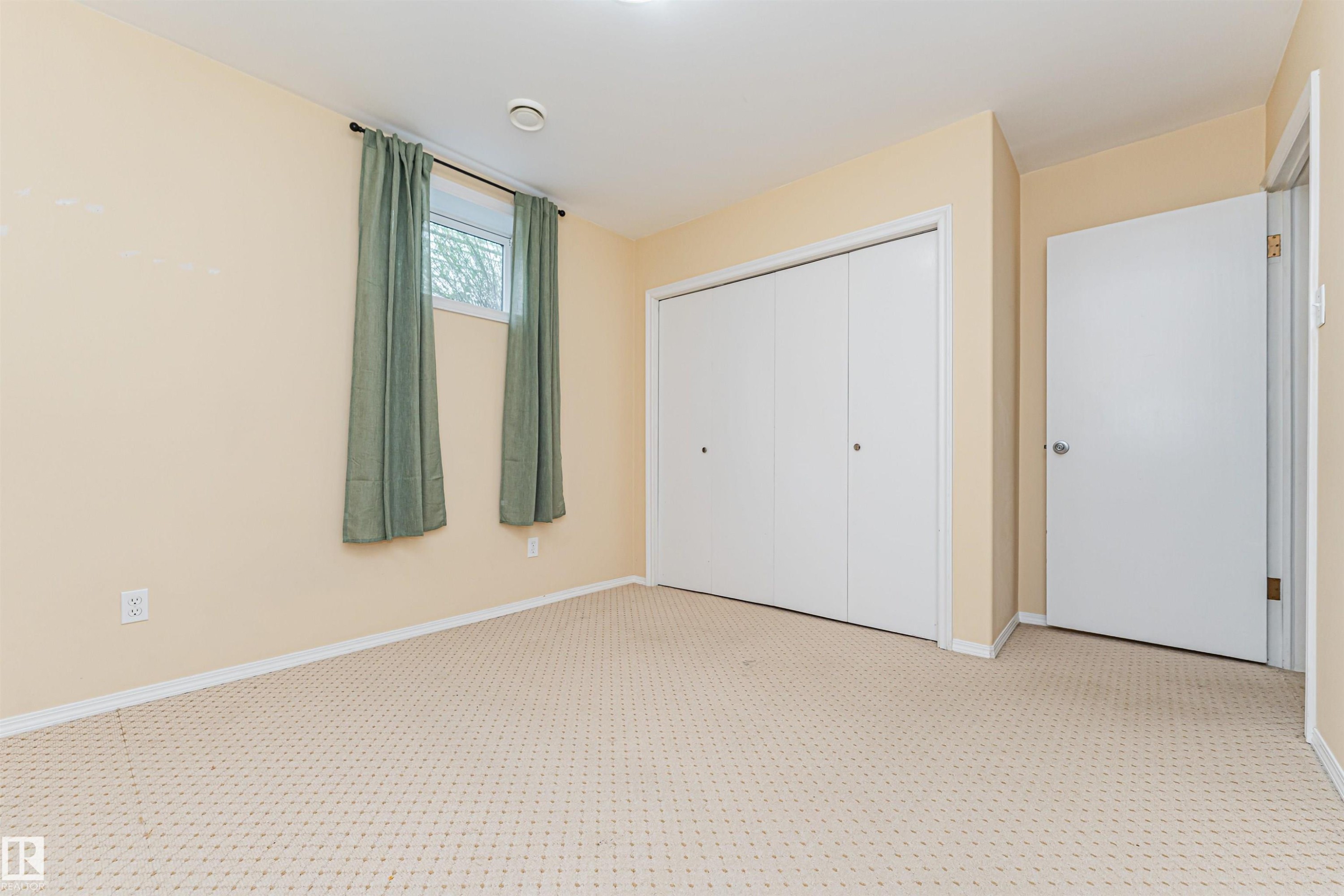 Textured carpet flooring, neutral-toned walls, white trim, recessed ceiling light, and a single window - 11139 62 Avenue Nw, Edmonton, AB - Indoor Photo Showing Other Room