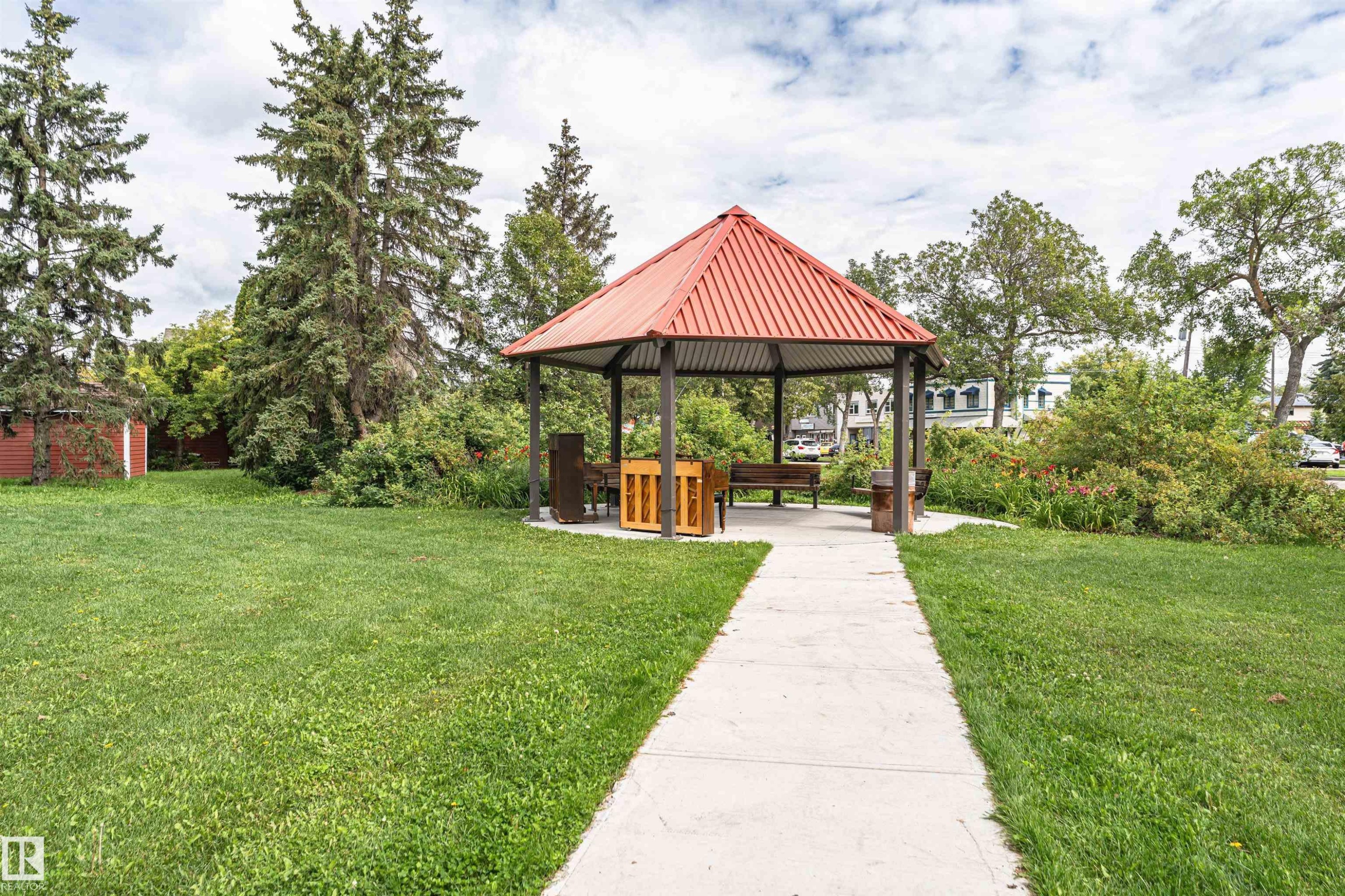 Gabled gazebo with a red metal roof, concrete pathway, and surrounding green lawn - 11139 62 Avenue Nw, Edmonton, AB - Outdoor With Backyard