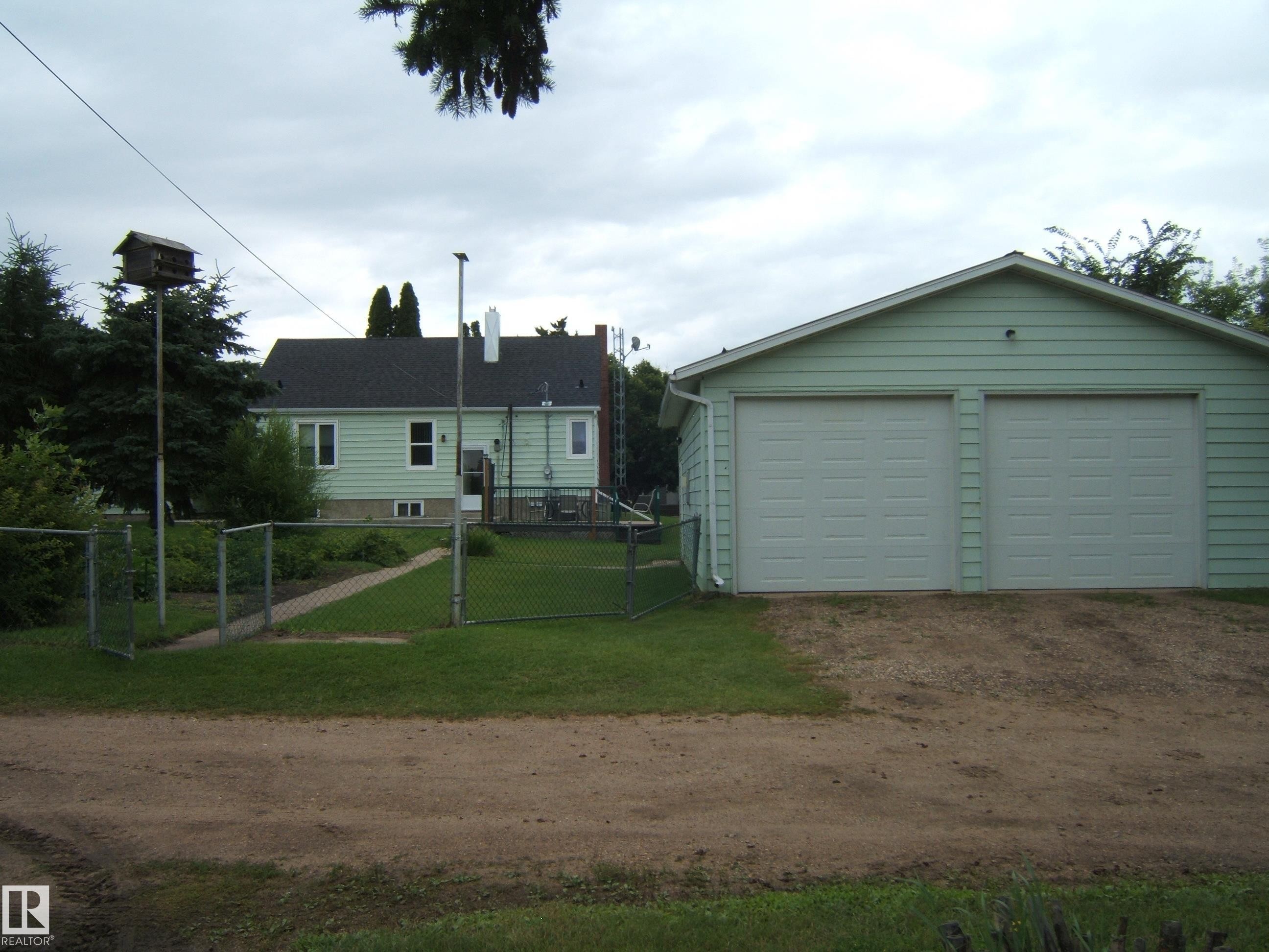 Two-car garage with panel doors and light green siding - 4809 47A Street, Two Hills, AB - Outdoor
