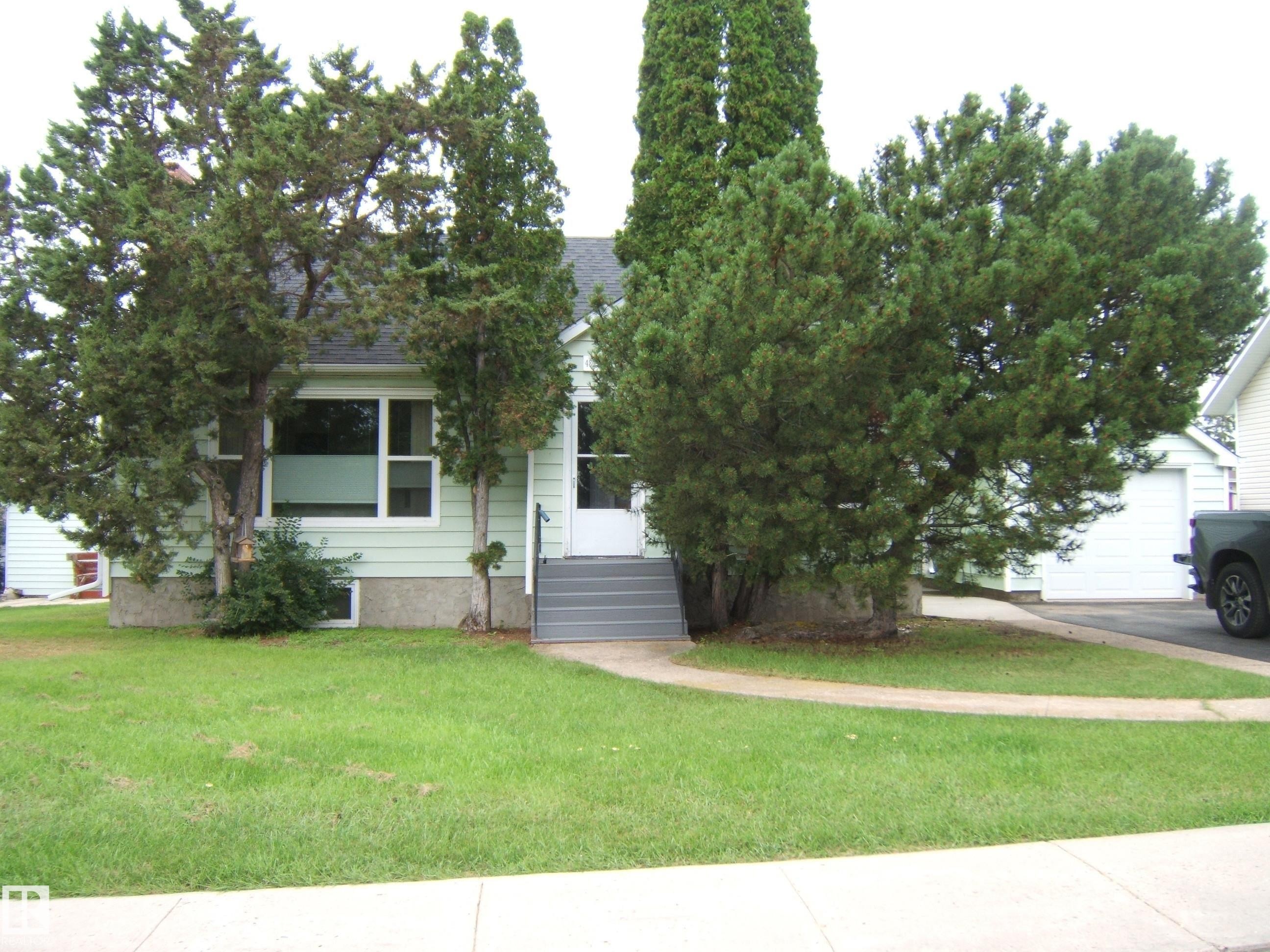 Charming single-story home with a welcoming front elevation featuring horizontal siding and large front-facing windows - 4809 47A Street, Two Hills, AB - Outdoor