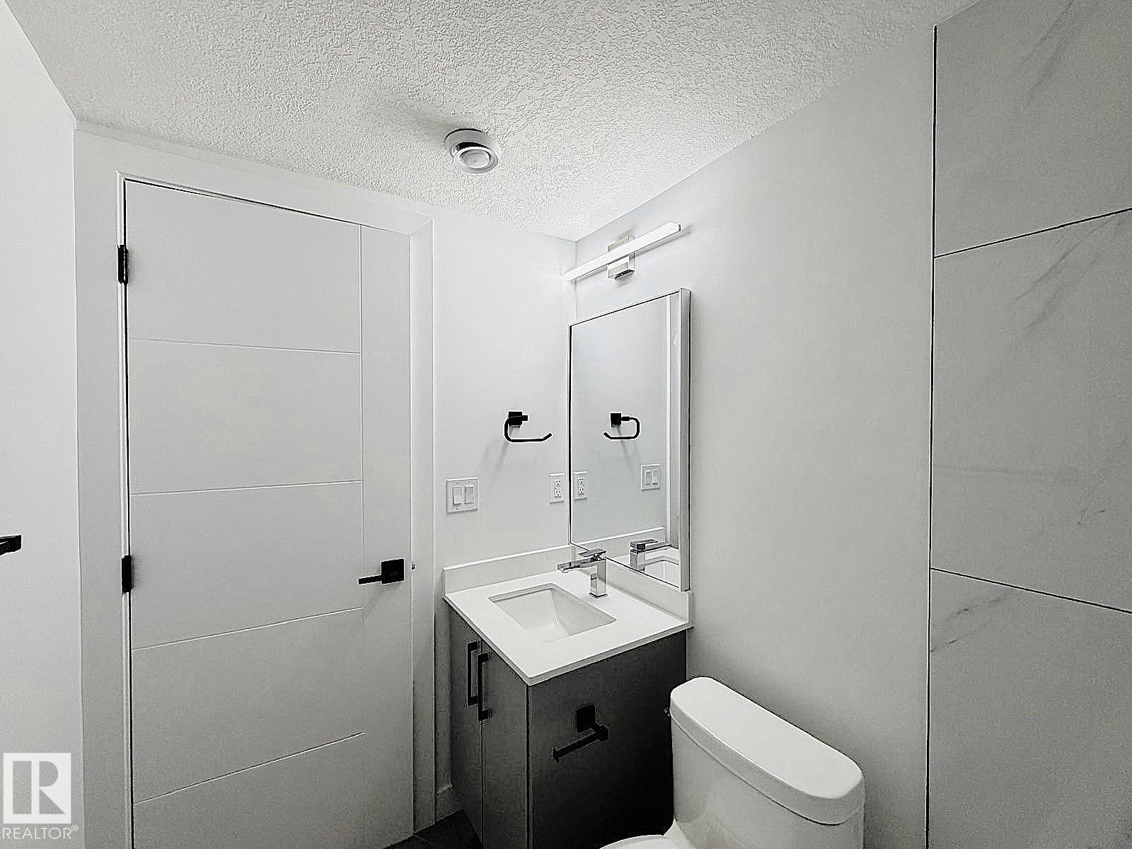 Integrated vanity with a rectangular basin sink, chrome faucet, and quartz countertop - 1312 35 Street Nw, Edmonton, AB