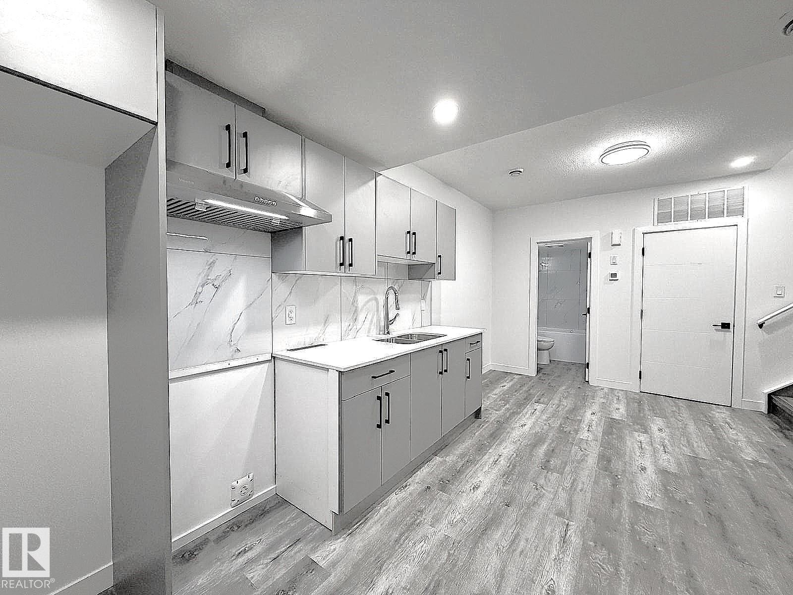 Kitchenette featuring light gray cabinetry, white countertops, and a white marble-look backsplash - 1312 35 Street Nw, Edmonton, AB