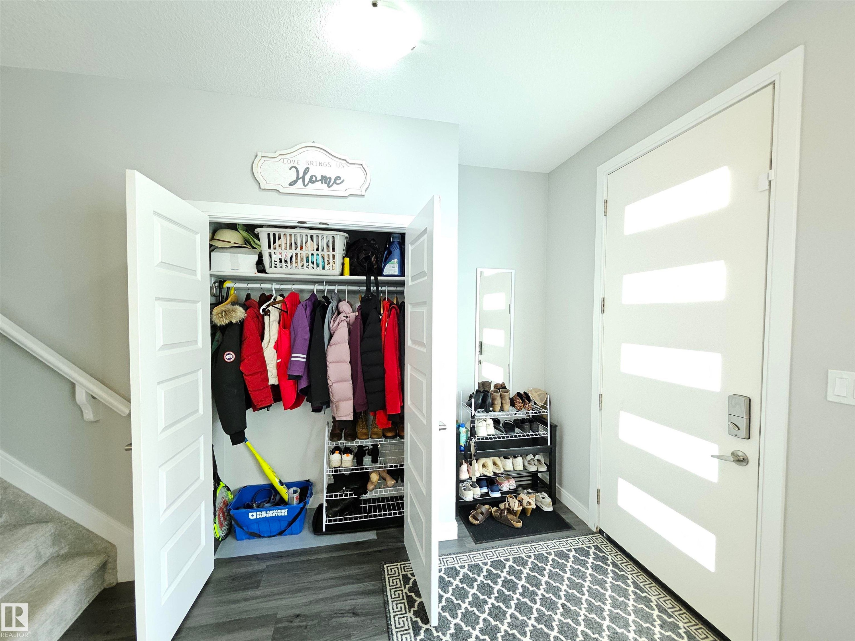 Dedicated mudroom entry featuring built-in shelving, a spacious closet with double doors and hanging rod, dark wood-finish flooring, and recessed lighting - 15212 98 Avenue Nw, Edmonton, AB - Indoor Photo Showing Other Room