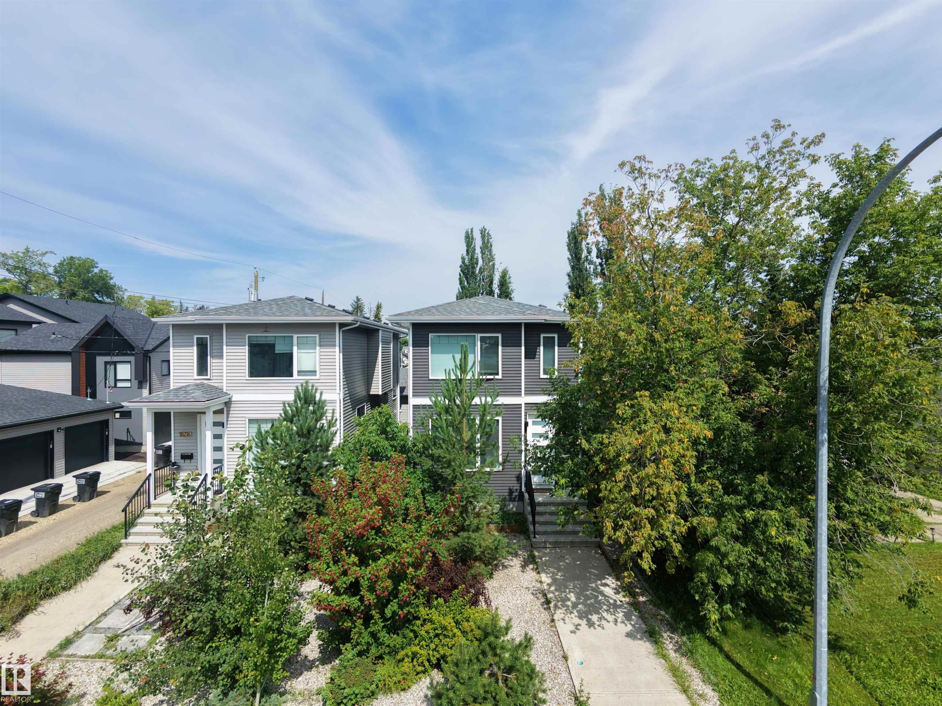 Contemporary two-story exterior with light gray siding, dark gray accents, and a covered entry - 15212 98 Avenue Nw, Edmonton, AB - Outdoor