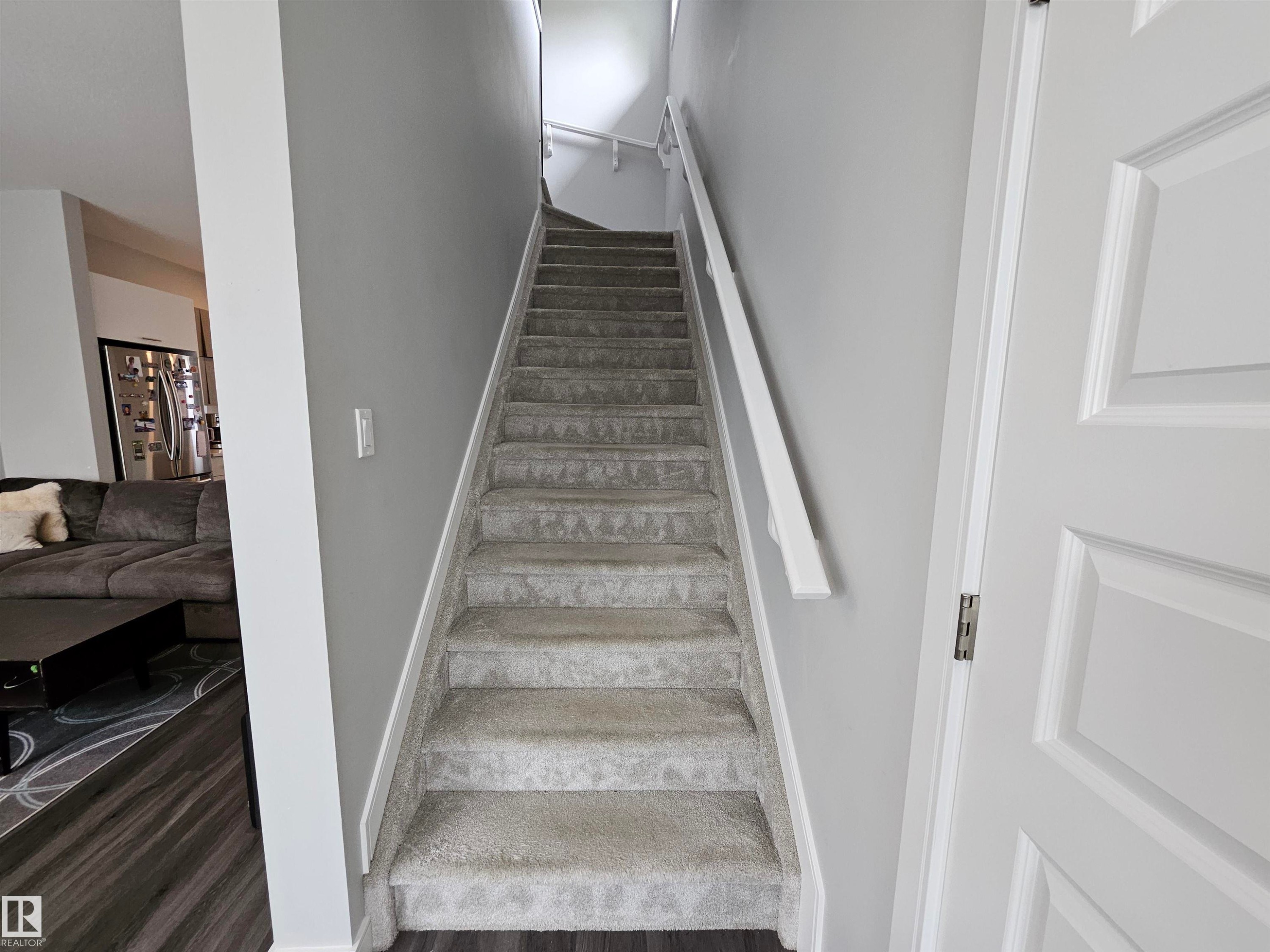 Carpeted staircase with white handrail and painted walls - 15212 98 Avenue Nw, Edmonton, AB - Indoor Photo Showing Other Room