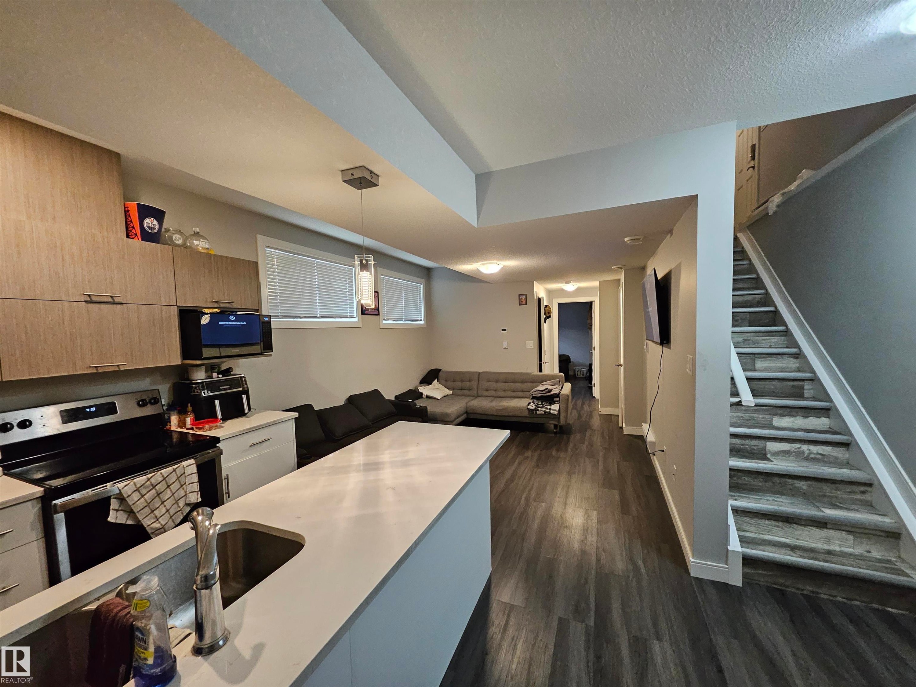 Kitchen with light wood-finish cabinetry, stainless steel range, and built-in microwave - 15212 98 Avenue Nw, Edmonton, AB - Indoor Photo Showing Kitchen