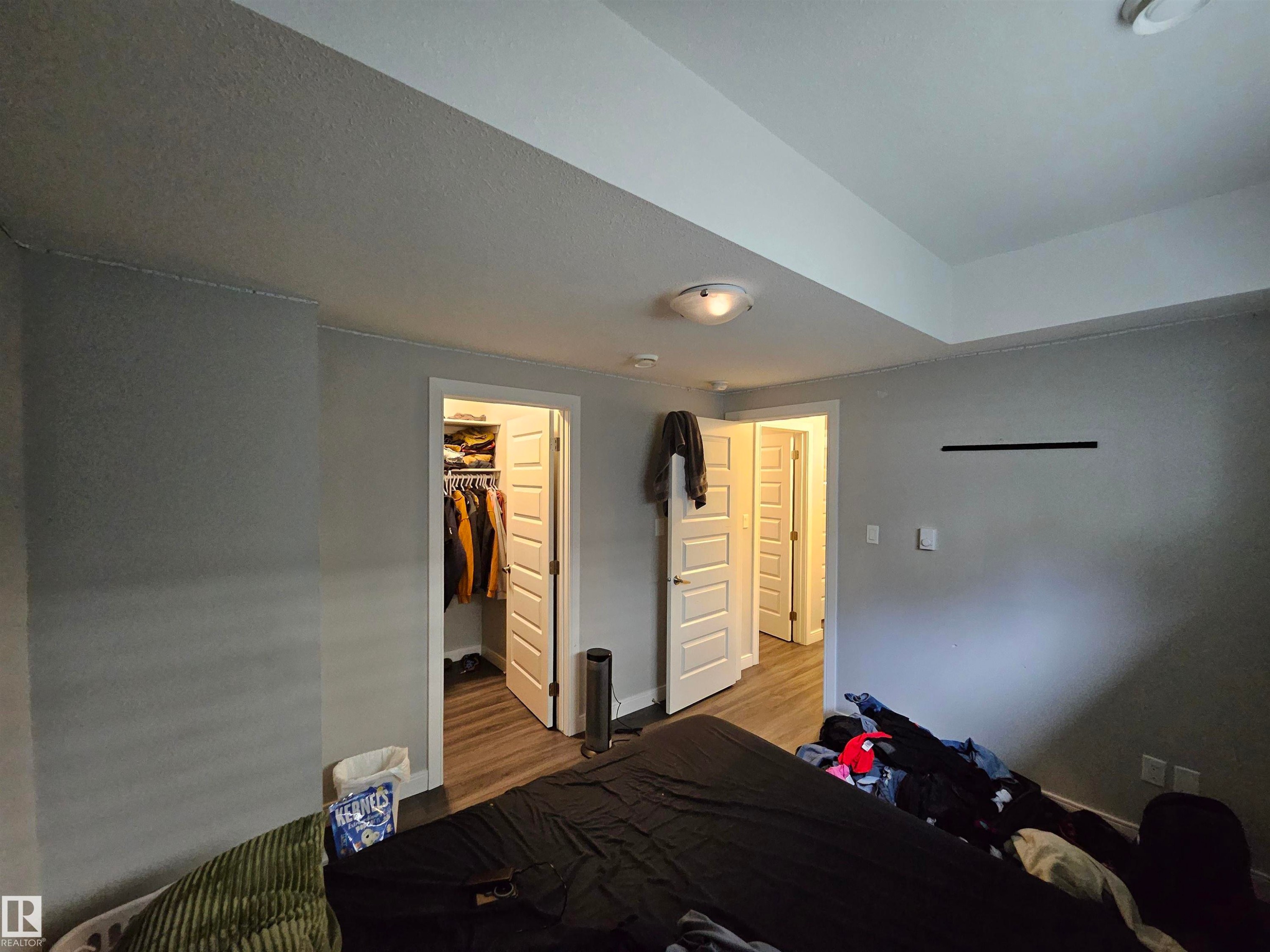 Recessed ceiling, neutral wall paint, wood-finish flooring, paneled interior doors, and overhead lighting - 15212 98 Avenue Nw, Edmonton, AB - Indoor Photo Showing Other Room