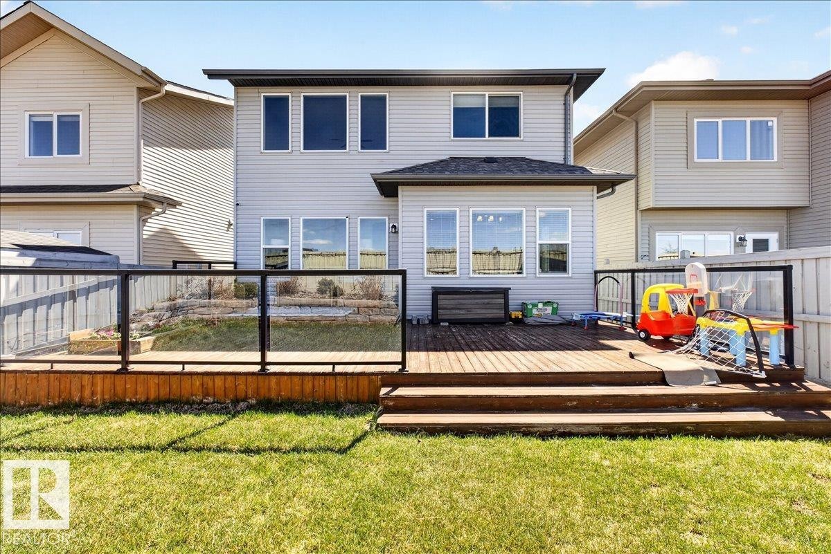 Expansive composite deck featuring multi-level composite decking with black metal railings, overlooking a manicured lawn - 3936 Claxton Loop Sw, Edmonton, AB - Outdoor With Deck Patio Veranda