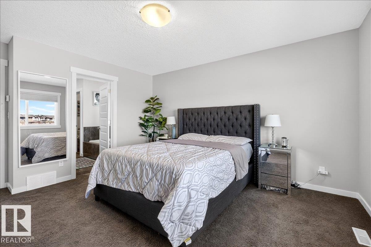 Neutral wall paint, textured ceiling, flush mount ceiling light, and carpeted flooring - 3936 Claxton Loop Sw, Edmonton, AB - Indoor Photo Showing Bedroom