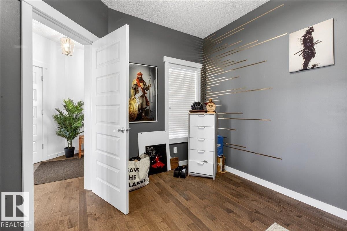 Hardwood-style flooring throughout - 3936 Claxton Loop Sw, Edmonton, AB - Indoor Photo Showing Other Room