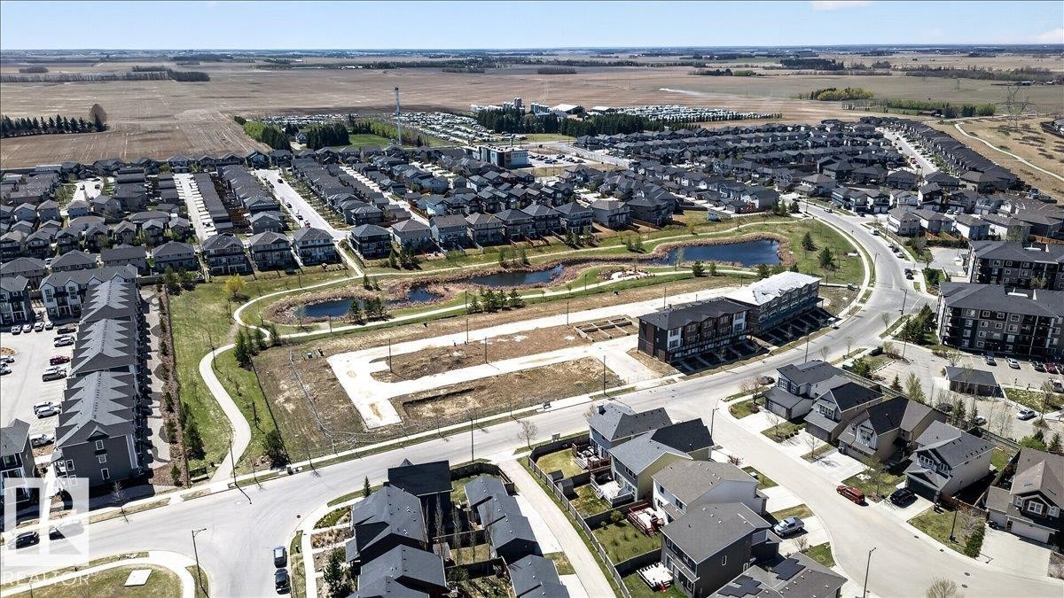 Expansive residential development with contemporary housing, a paved walking path, and two retention ponds - 3936 Claxton Loop Sw, Edmonton, AB - Outdoor With View