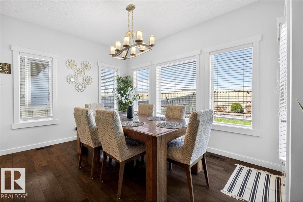 Bright dining room flooded with natural light through multiple large windows and glass doors featuring plantation shutters - 3936 Claxton Loop Sw, Edmonton, AB - Indoor Photo Showing Dining Room