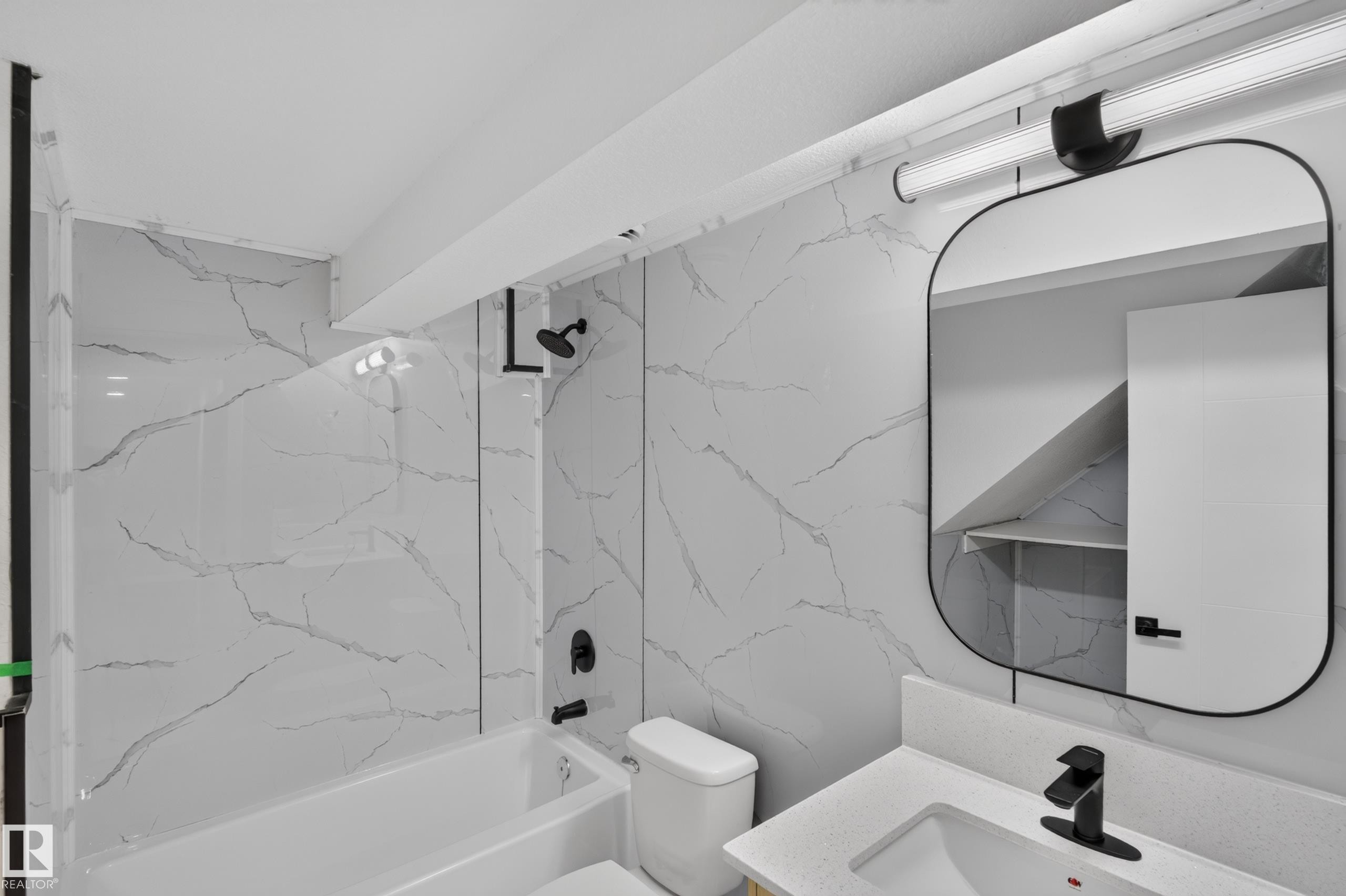 Bathtub with black hardware and marble-patterned wall surfacing - 175 Centennial Crest Nw, Edmonton, AB - Indoor Photo Showing Bathroom
