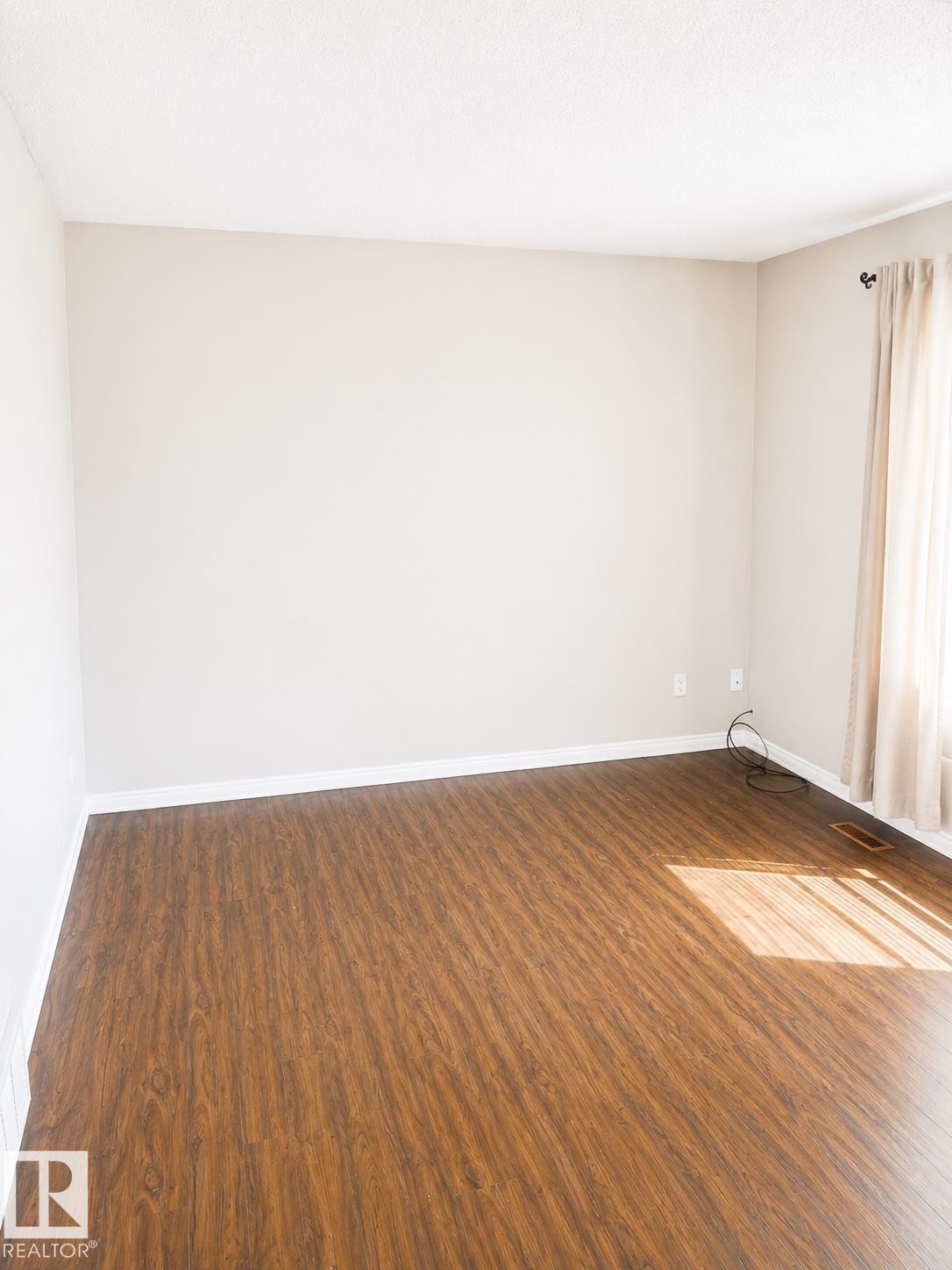 Wood-finish flooring with neutral wall paint and white trim - 802 16 Avenue, Cold Lake, AB - Indoor Photo Showing Other Room