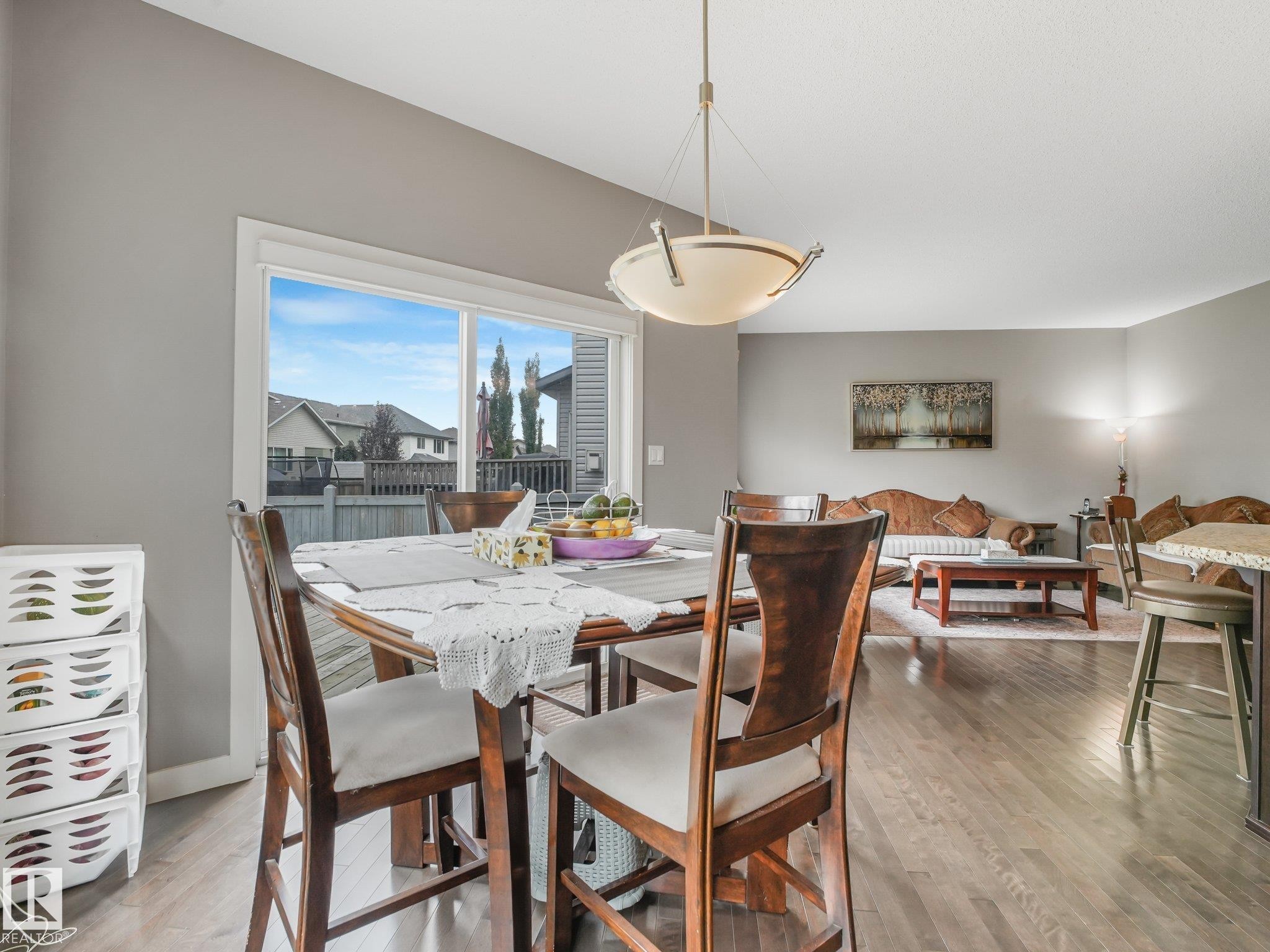 Hardwood-finish flooring throughout, vaulted ceiling, large picture window, and recessed lighting - 1478 37B Avenue Nw, Edmonton, AB - Indoor Photo Showing Dining Room