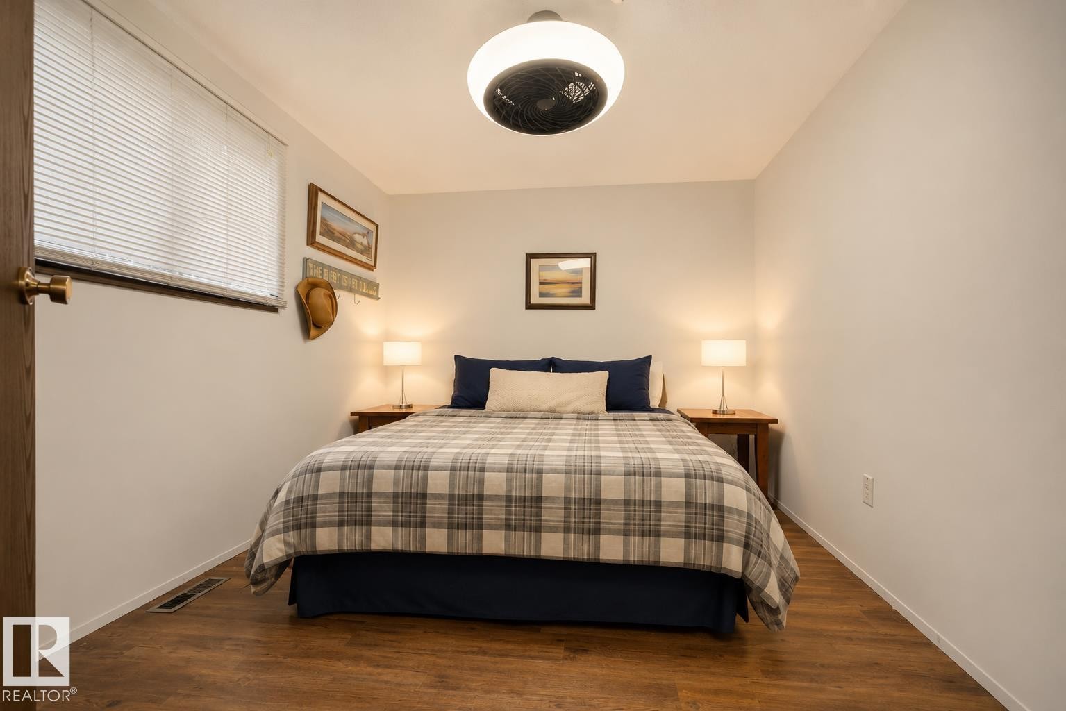 Wood-finish flooring, white horizontal blinds, and a ceiling-mounted light fixture with integrated fan - 264 Beach Avenue, Rural Barrhead County, AB - Indoor Photo Showing Bedroom
