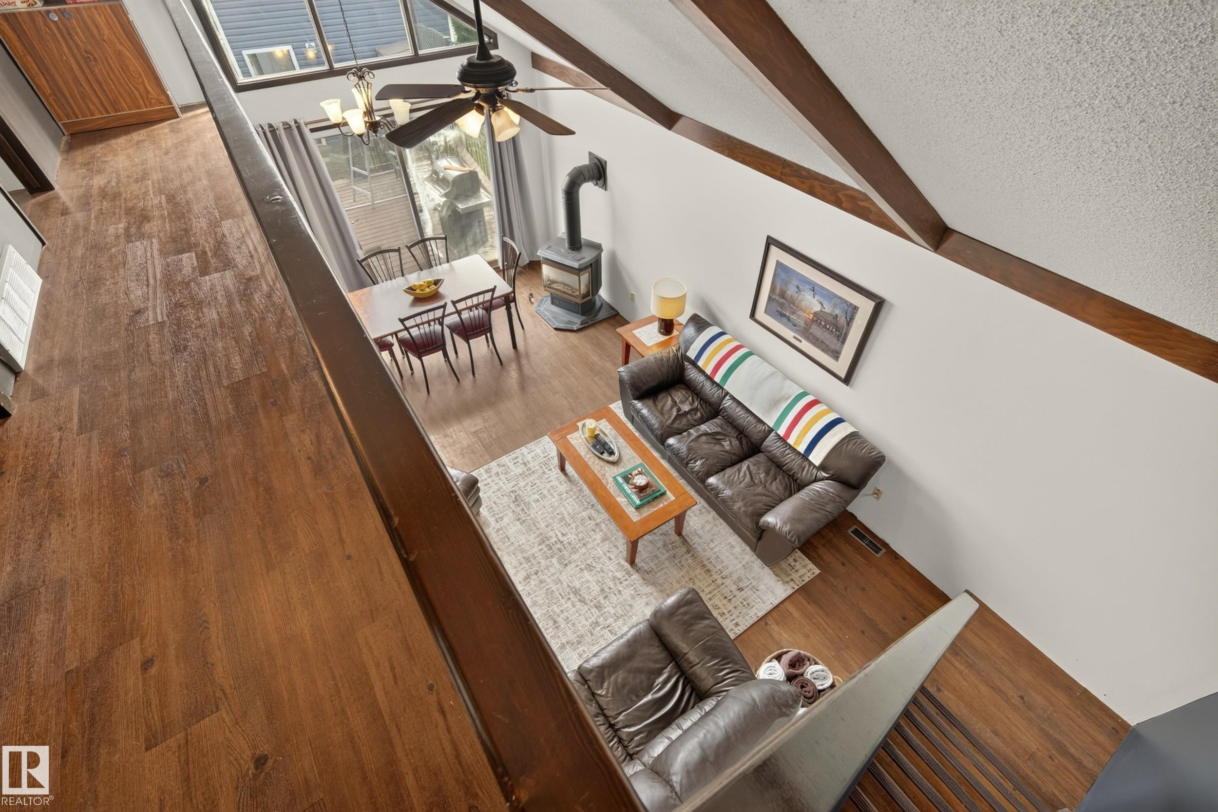Wood-finish flooring throughout, exposed ceiling beams, and a ceiling fan with integrated lighting - 264 Beach Avenue, Rural Barrhead County, AB - Indoor Photo Showing Other Room