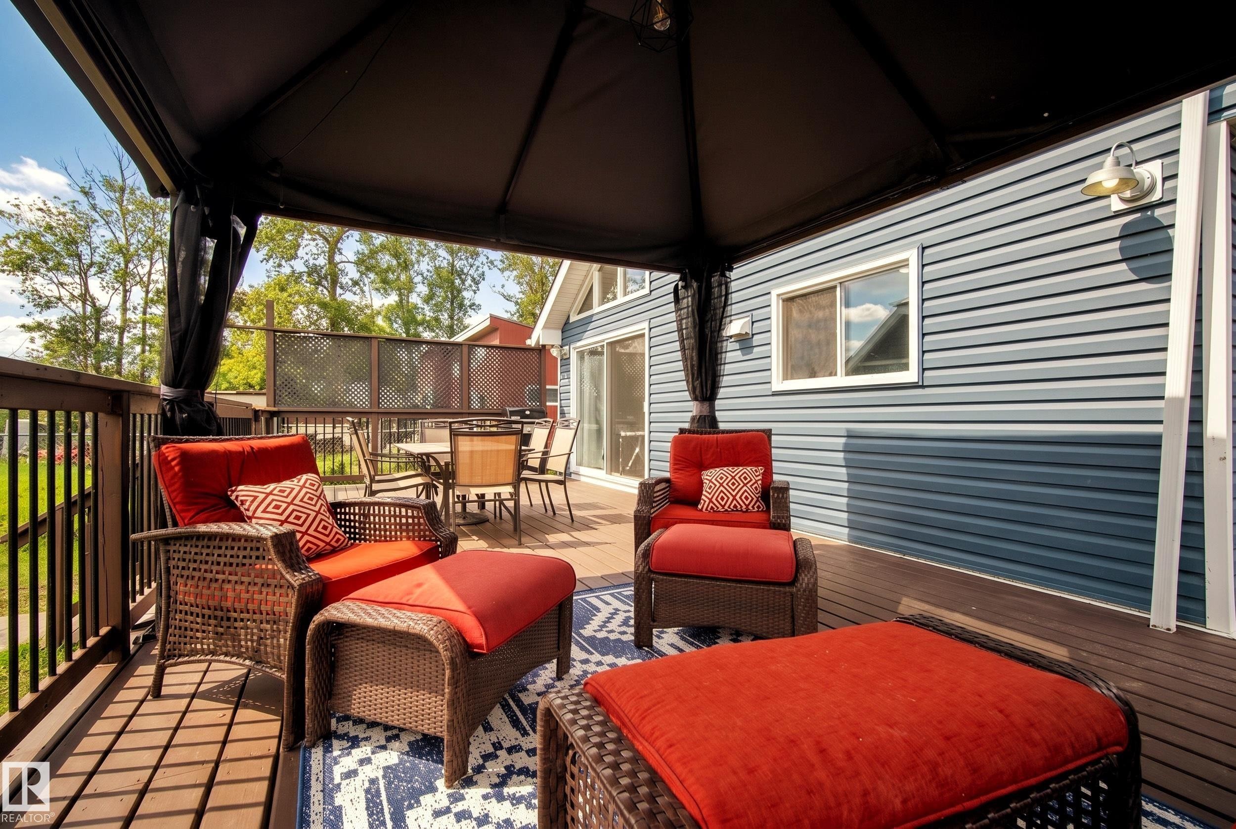 Expansive wood-finish deck with a dark-framed gazebo - 264 Beach Avenue, Rural Barrhead County, AB - Outdoor With Deck Patio Veranda With Exterior