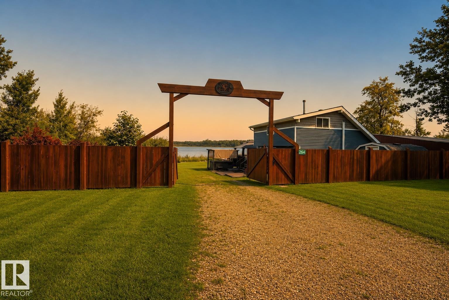 Gravel driveway leading to a wooden gate and perimeter fence - 264 Beach Avenue, Rural Barrhead County, AB - Outdoor