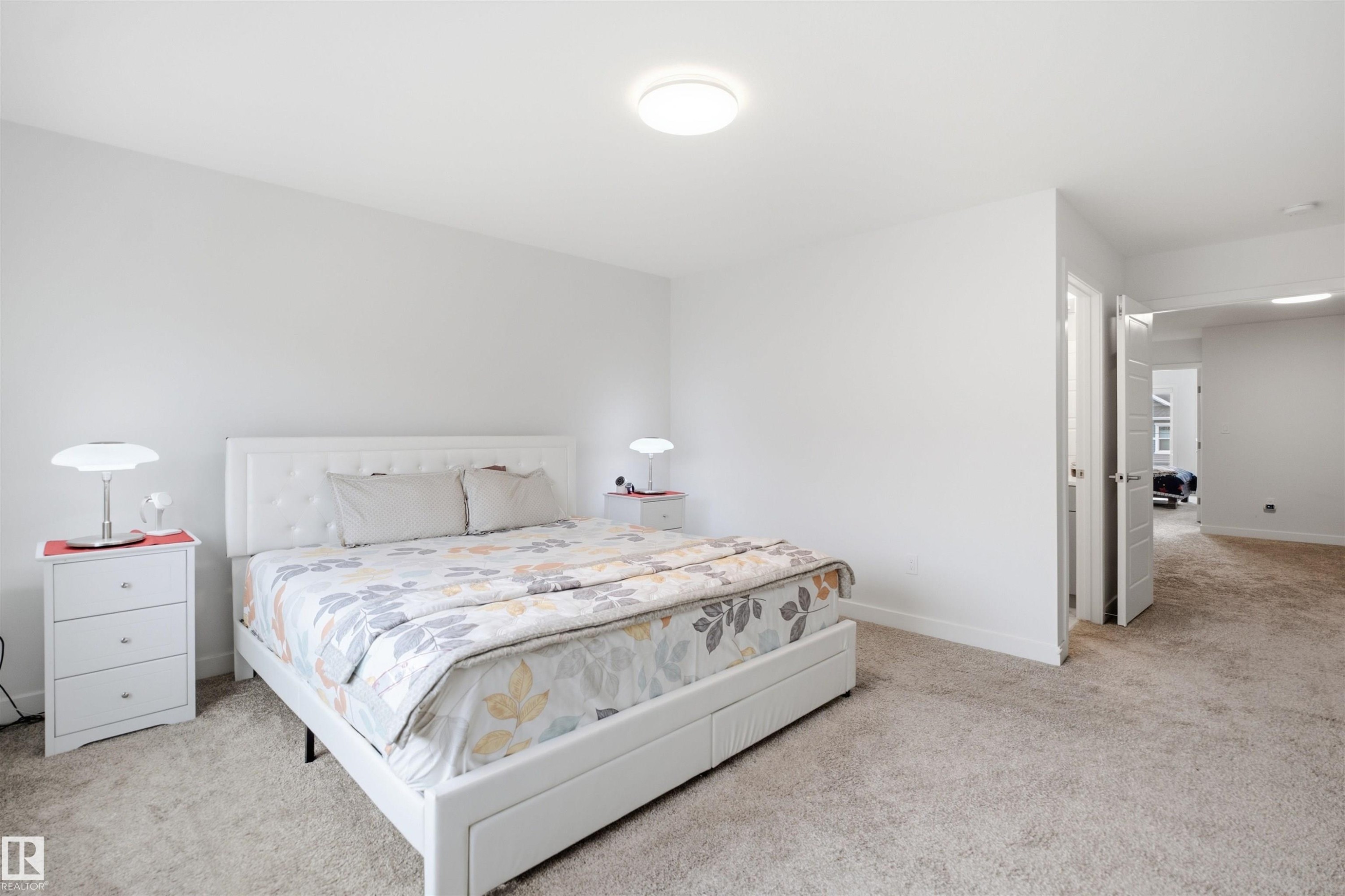Plush carpeted flooring with light-colored walls and a flush-mount ceiling light - 3877 Chrustawka Place Sw, Edmonton, AB - Indoor Photo Showing Bedroom