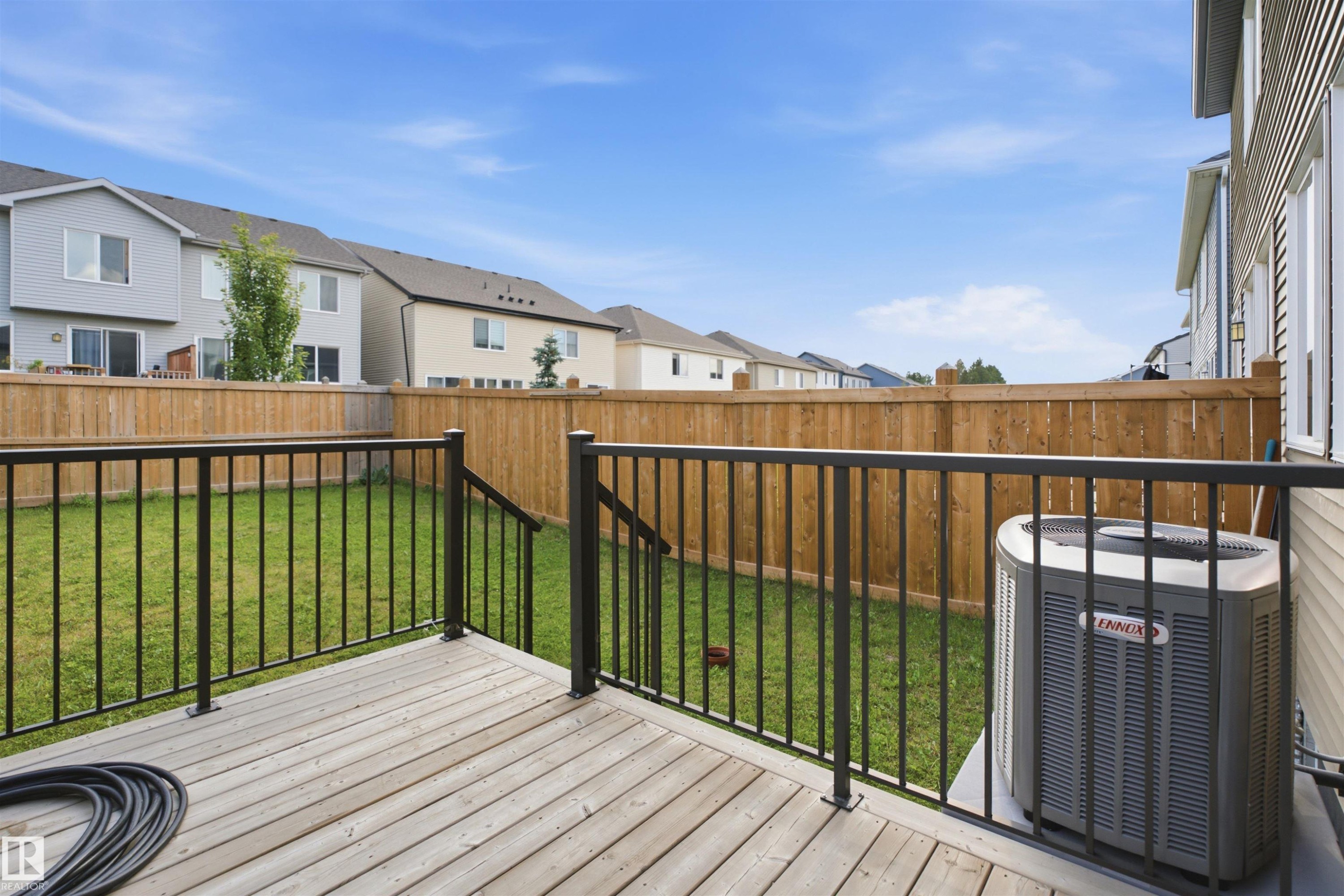 Upper-level wood-finish deck with black metal railings - 3877 Chrustawka Place Sw, Edmonton, AB - Outdoor With Deck Patio Veranda With Exterior