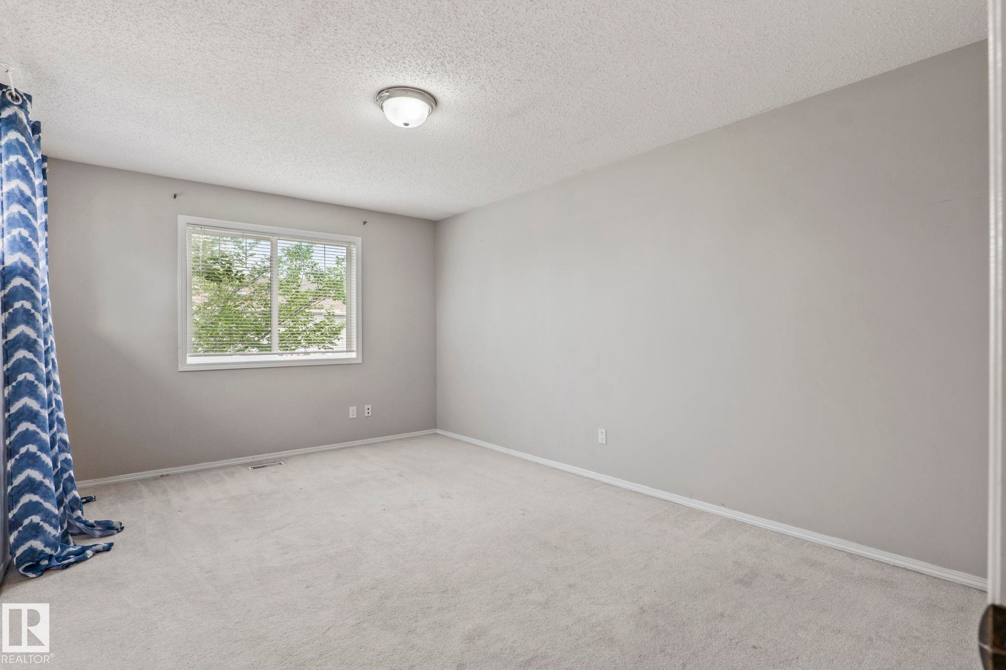 Wall-to-wall carpeting and a ceiling-mounted light fixture - #80 4350 23St Nw, Edmonton, AB - Indoor Photo Showing Other Room