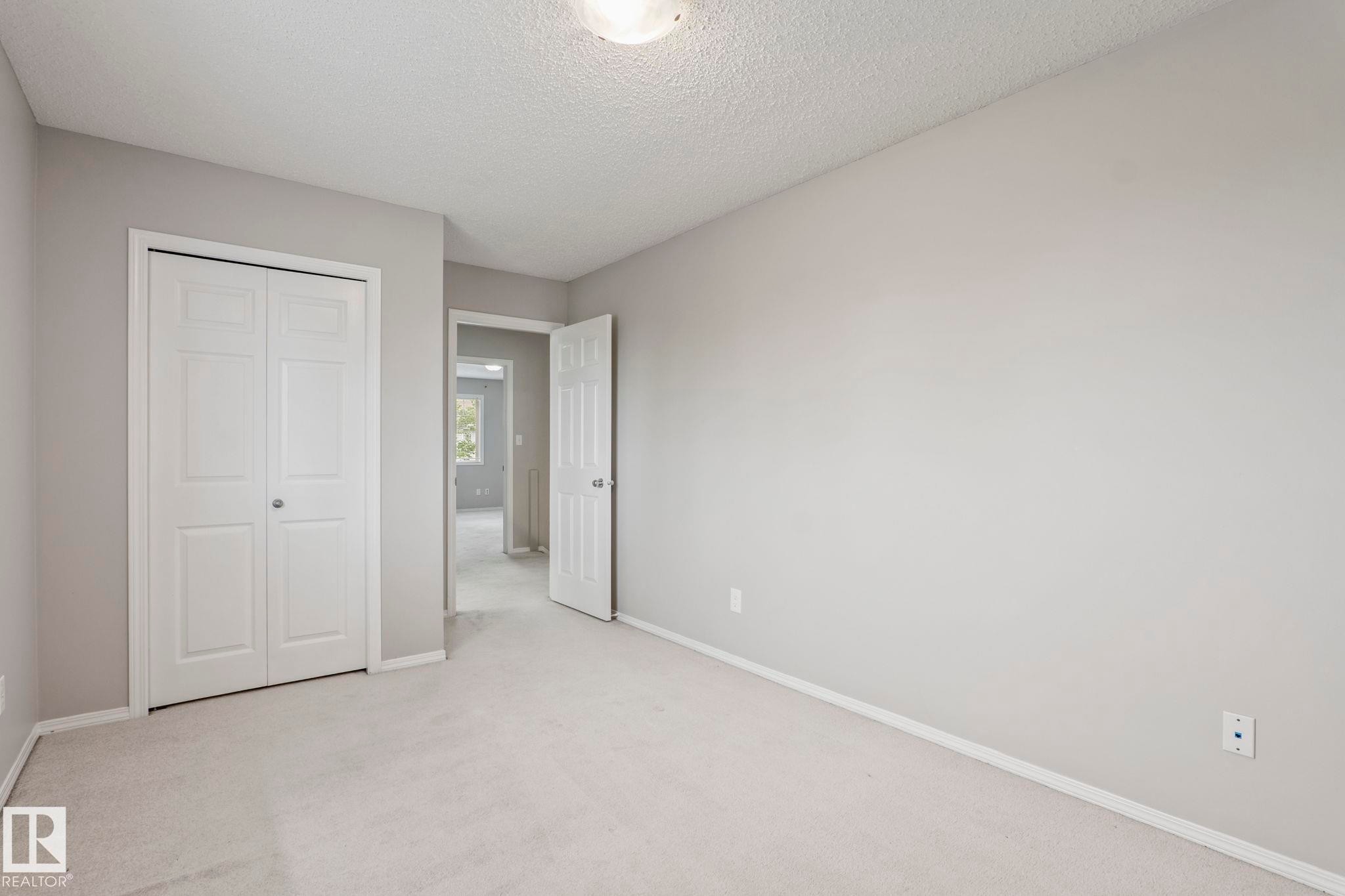 Neutral-toned walls, light-colored carpeting, white trim, and a ceiling-mounted light fixture - #80 4350 23St Nw, Edmonton, AB - Indoor Photo Showing Other Room