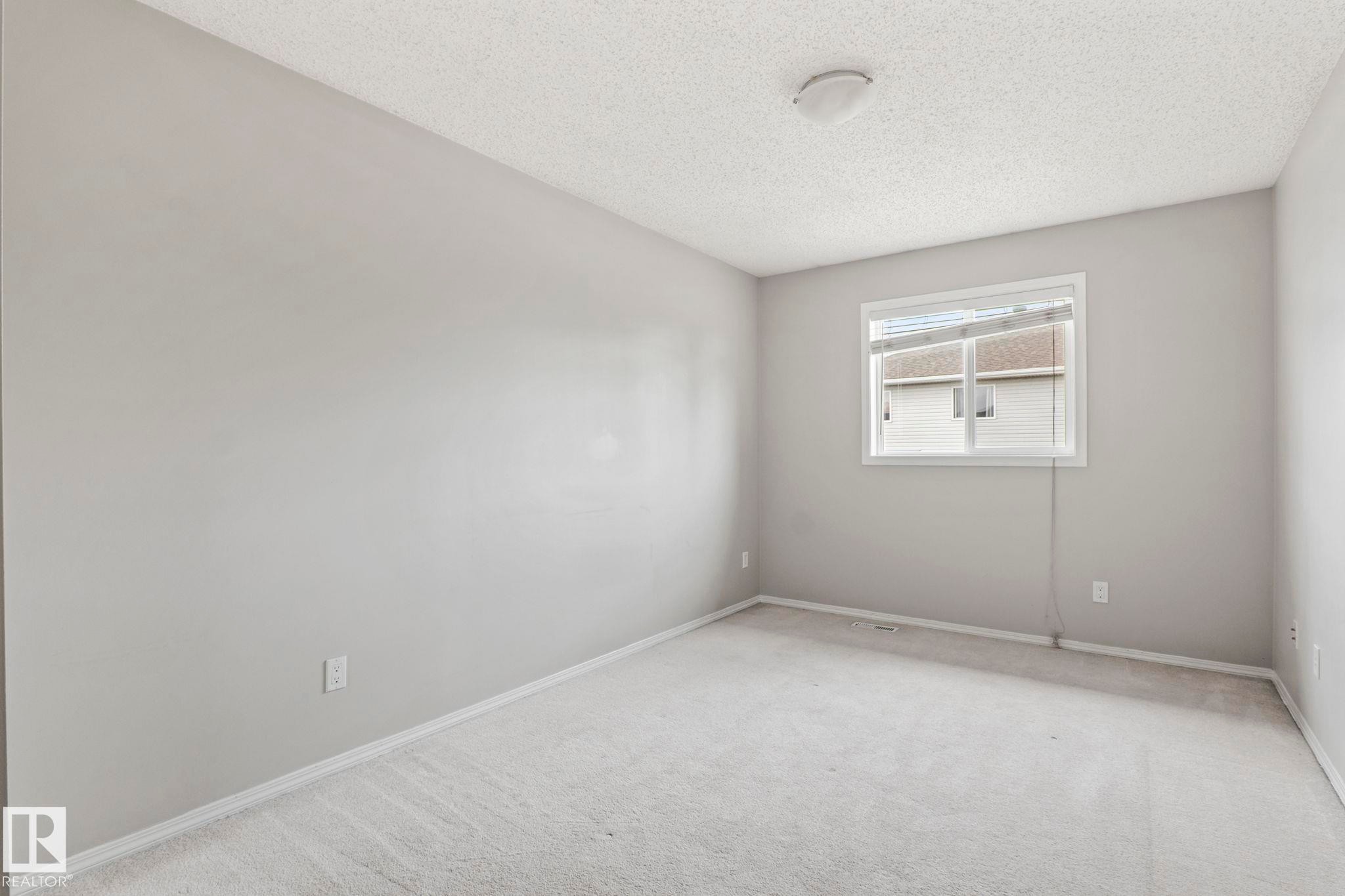 Recessed window with blinds, light gray wall paint, white trim, carpet flooring, and a ceiling-mounted light fixture - #80 4350 23St Nw, Edmonton, AB - Indoor Photo Showing Other Room