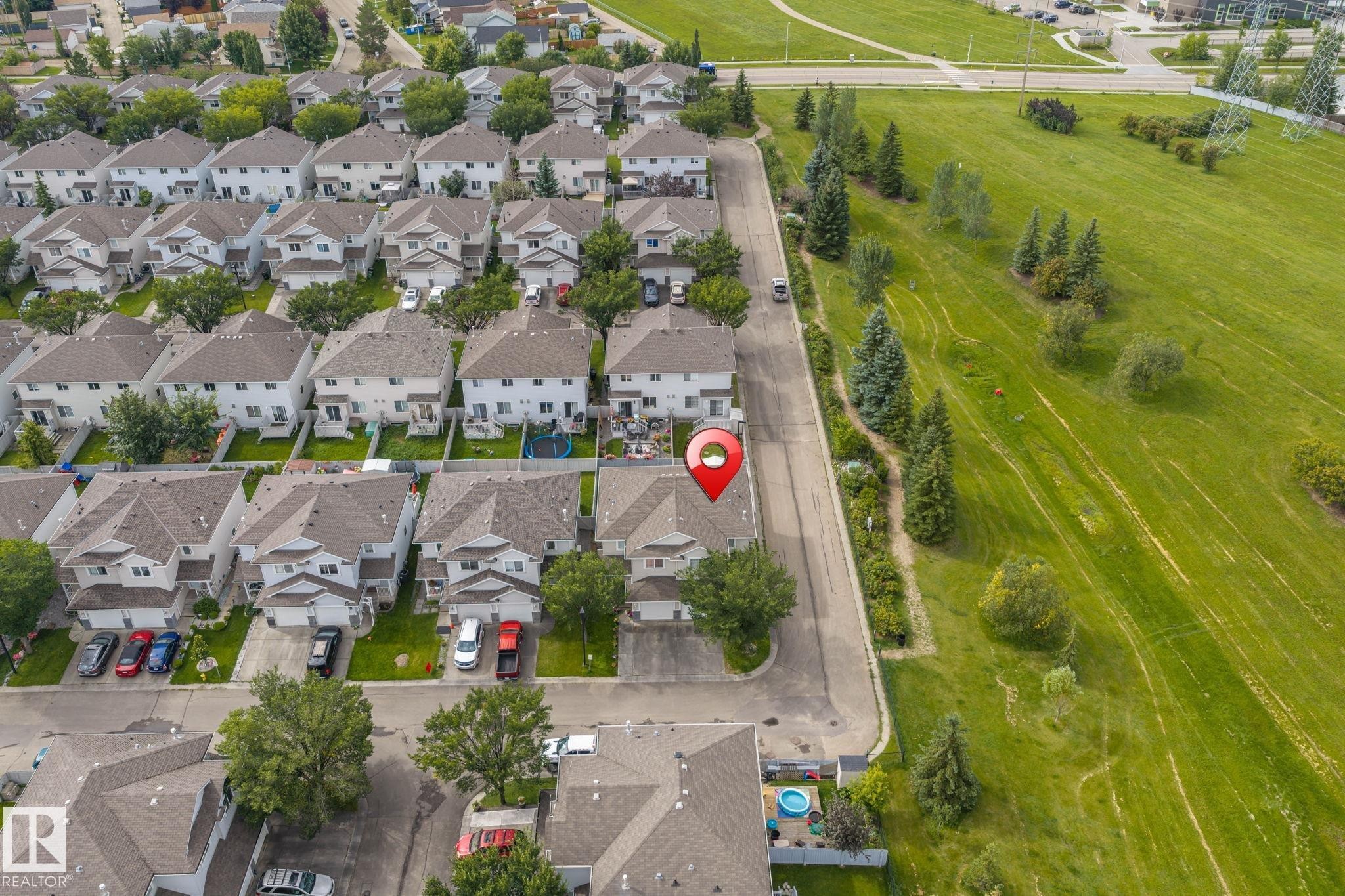 Residential neighborhood with uniform housing architecture, street parking, and manicured green spaces - #80 4350 23St Nw, Edmonton, AB - Outdoor With View