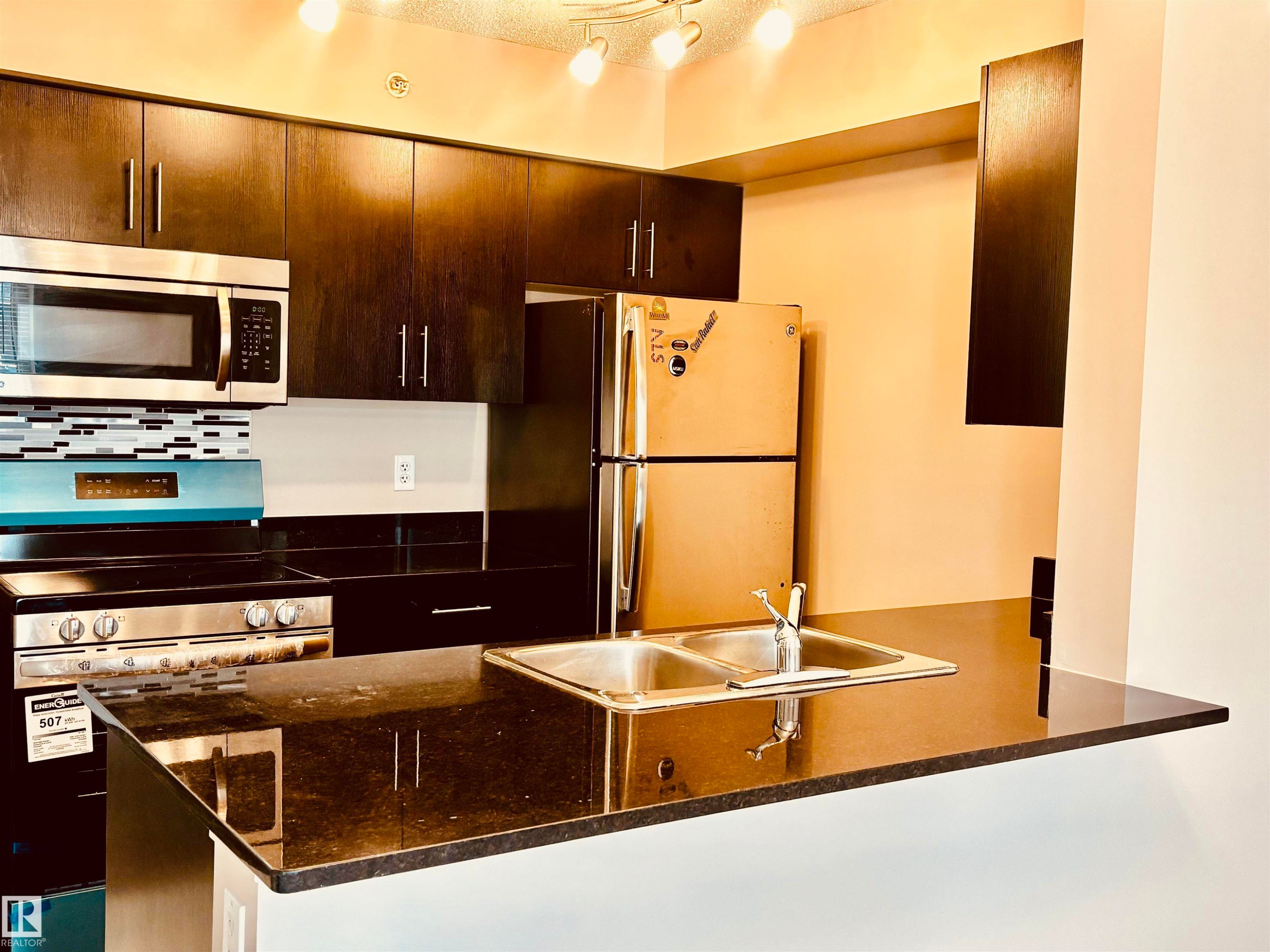 features s/s appliances and granite countertops - #409 12035 22 Av Sw, Edmonton, AB - Indoor Photo Showing Kitchen With Stainless Steel Kitchen With Double Sink