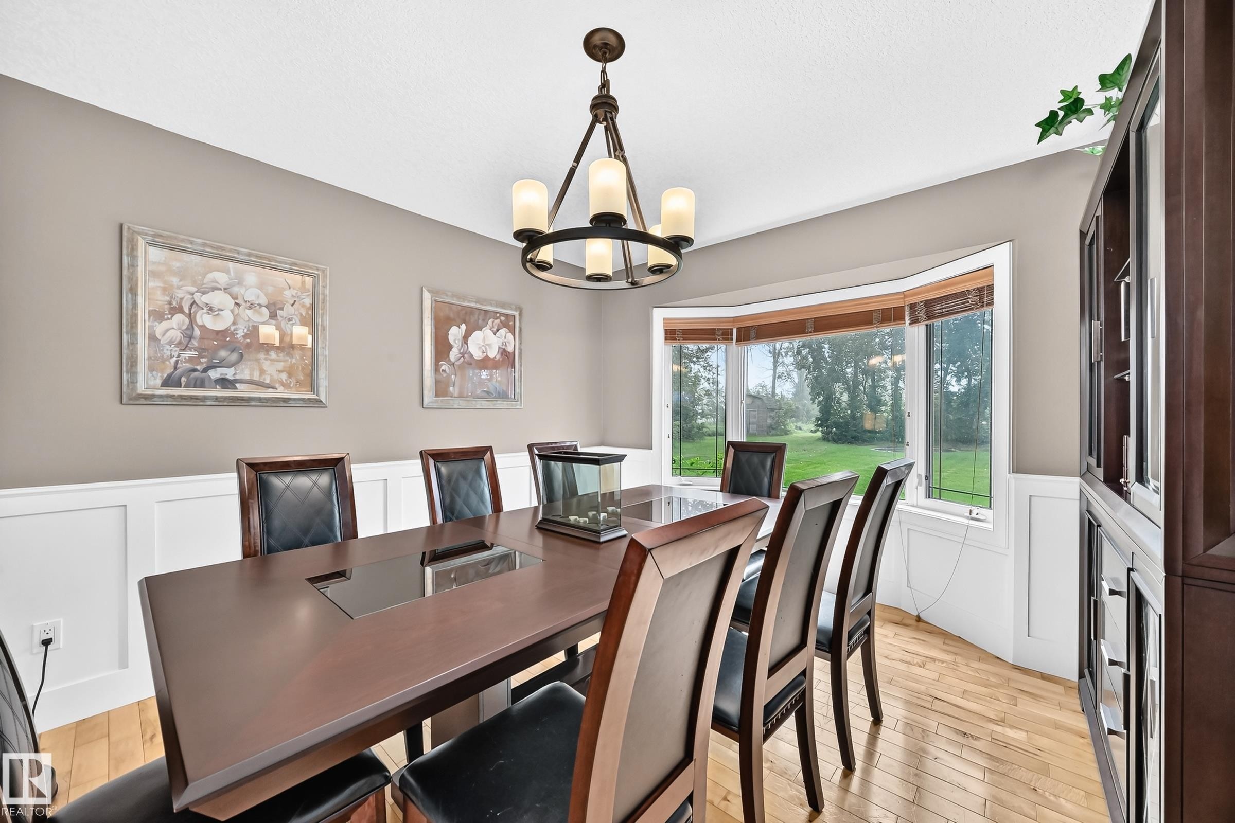 Hardwood flooring, wainscoting, bay window, chandelier lighting, and a built-in display cabinet - #38 24512 Sturgeon Rd, Rural Sturgeon County, AB