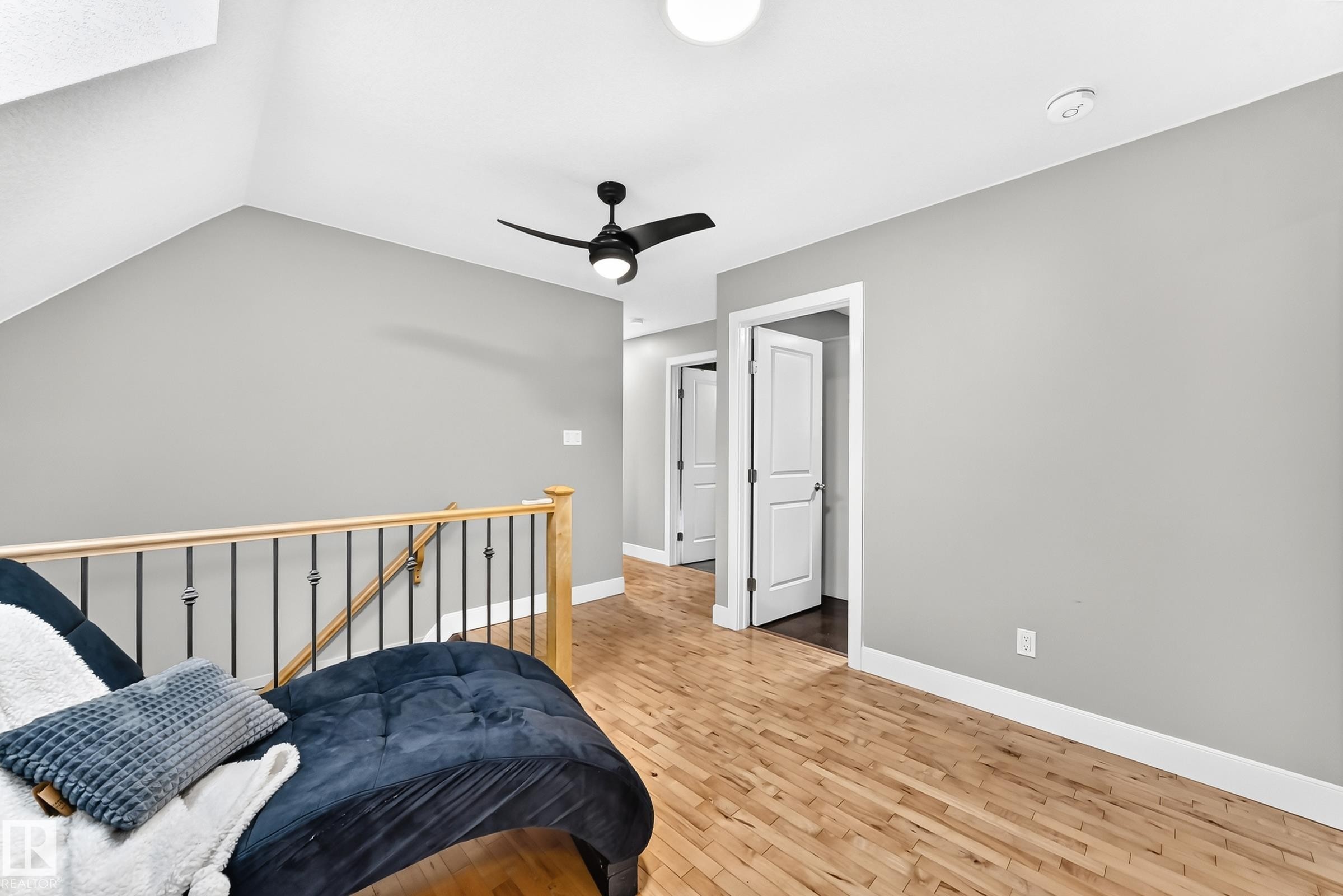 Wood-finish flooring, staircase with wood handrail and iron balusters, ceiling fan, recessed lighting, and white interior doors - #38 24512 Sturgeon Rd, Rural Sturgeon County, AB