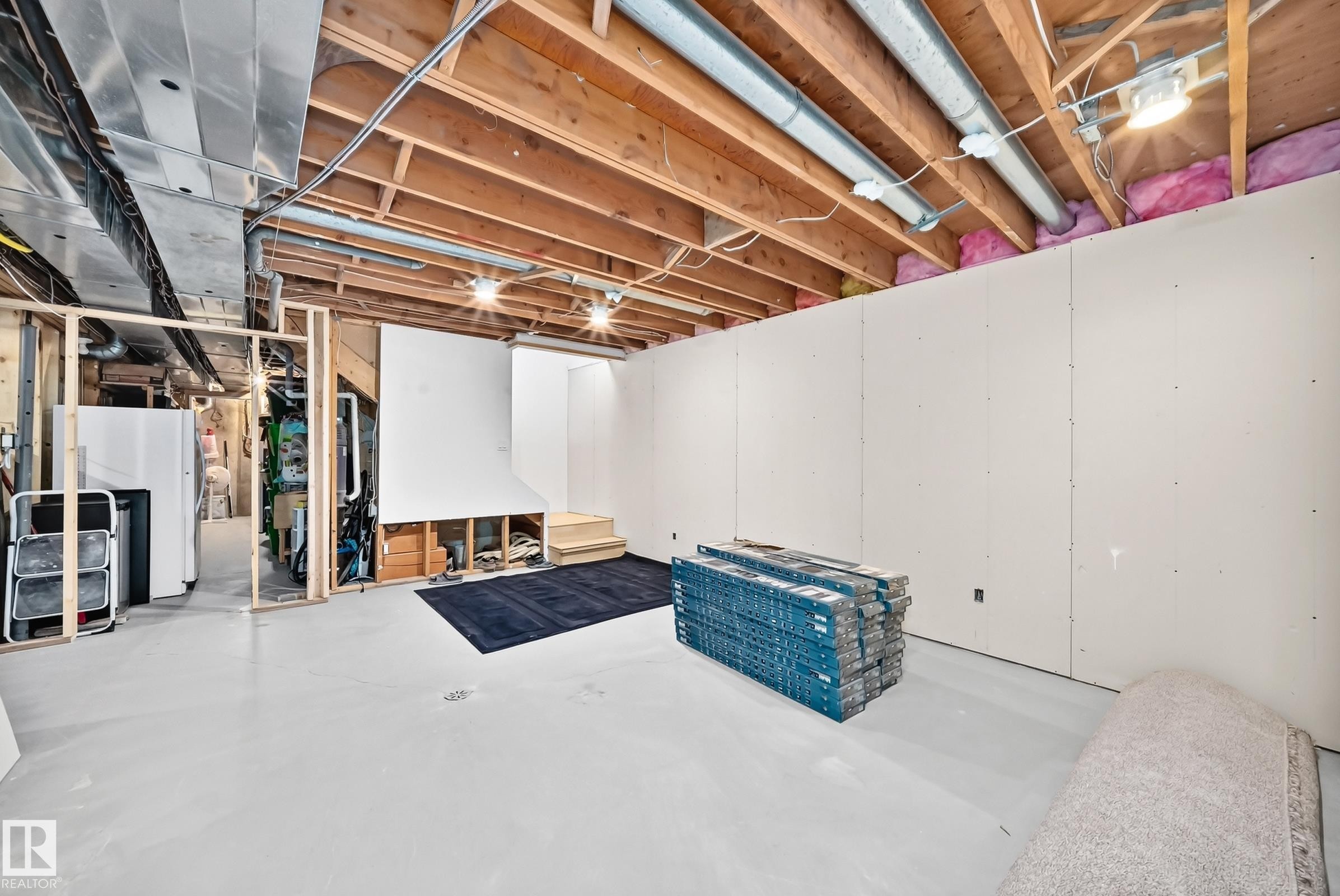 Unfinished lower level featuring exposed wood joists, partial drywall installation, and framed partition walls - #38 24512 Sturgeon Rd, Rural Sturgeon County, AB