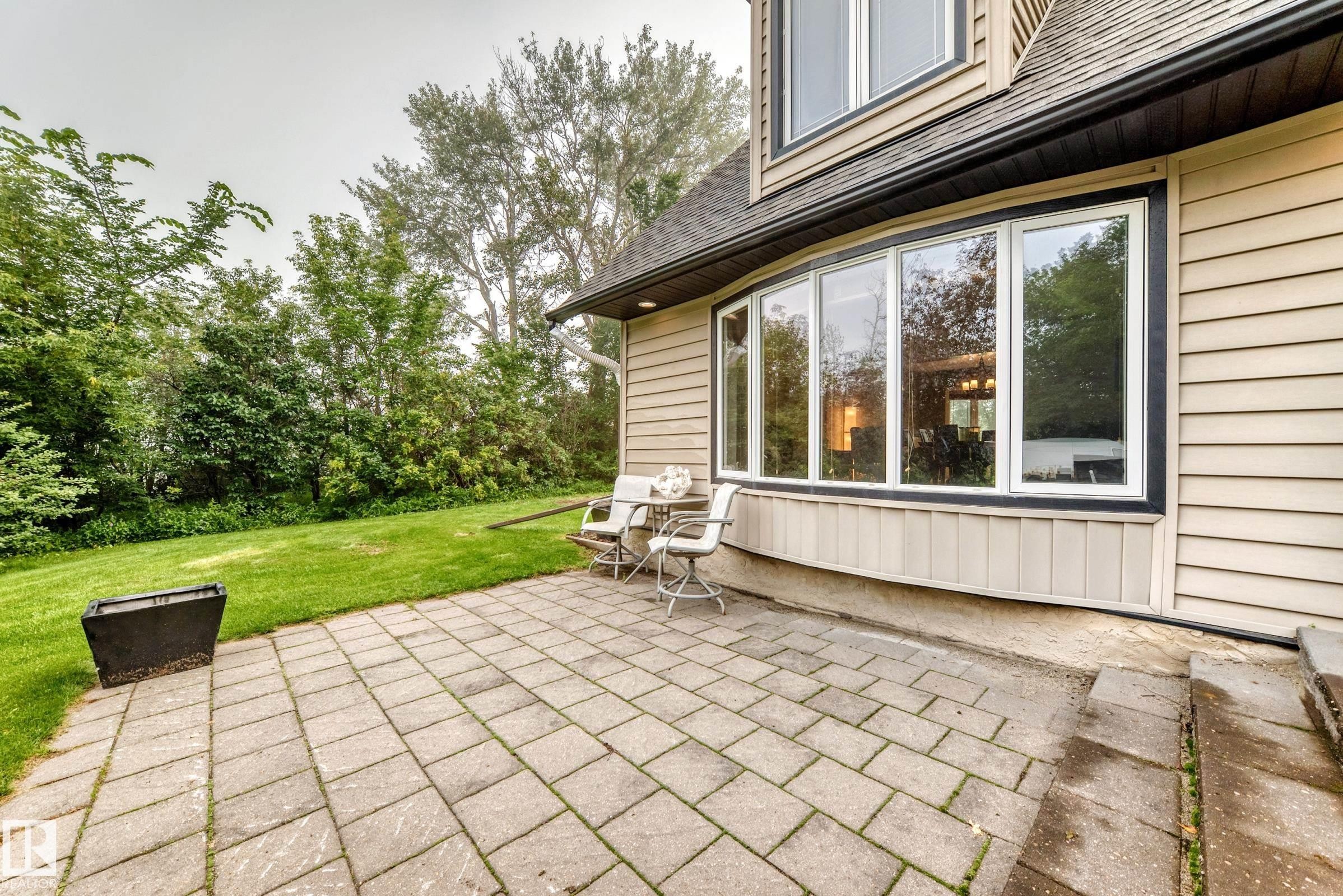 Paved patio area, expansive lawn, and a large bay window - #38 24512 Sturgeon Rd, Rural Sturgeon County, AB